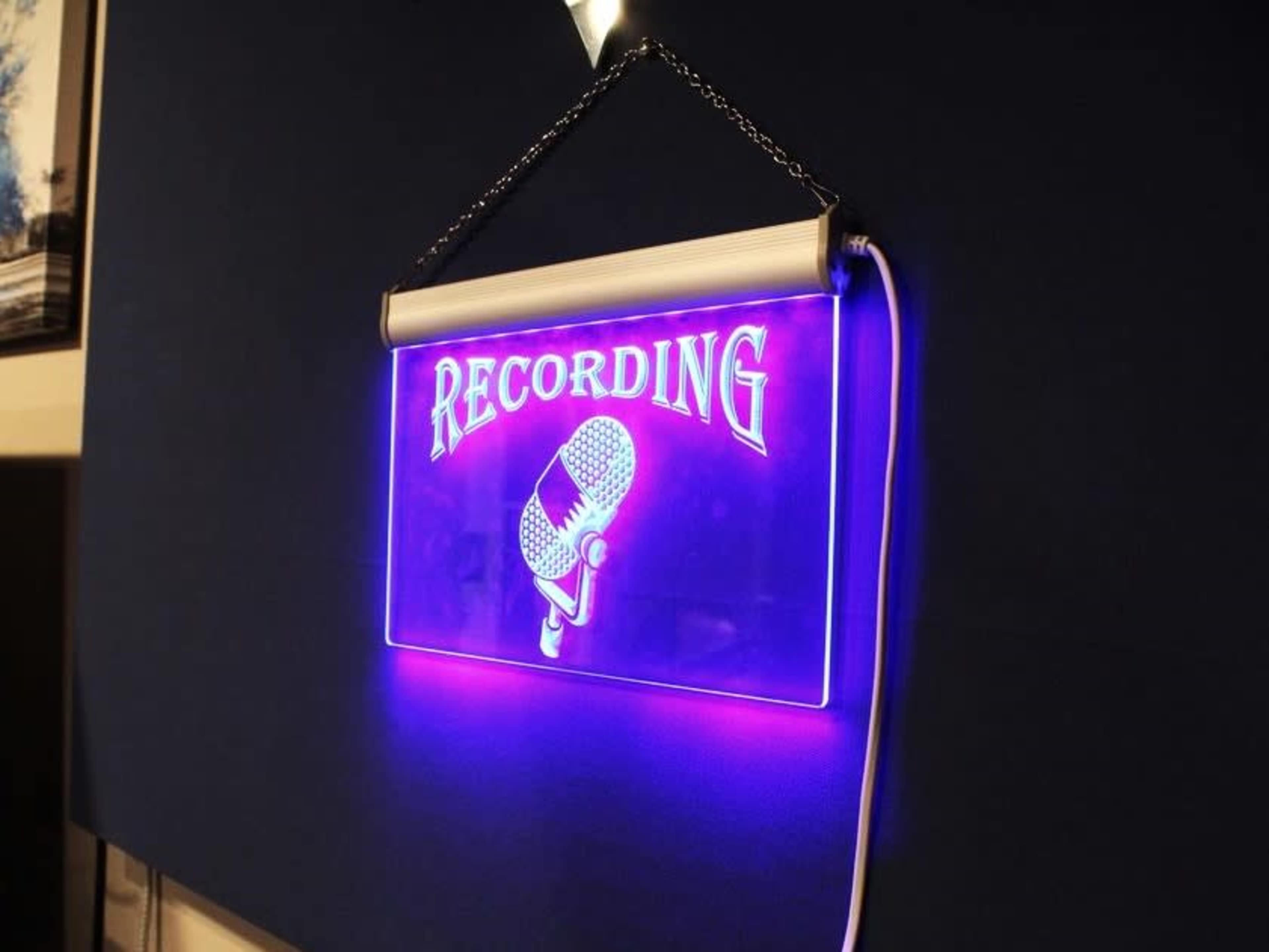 A hanging neon sign displays the word "RECORDING" alongside a microphone graphic.
