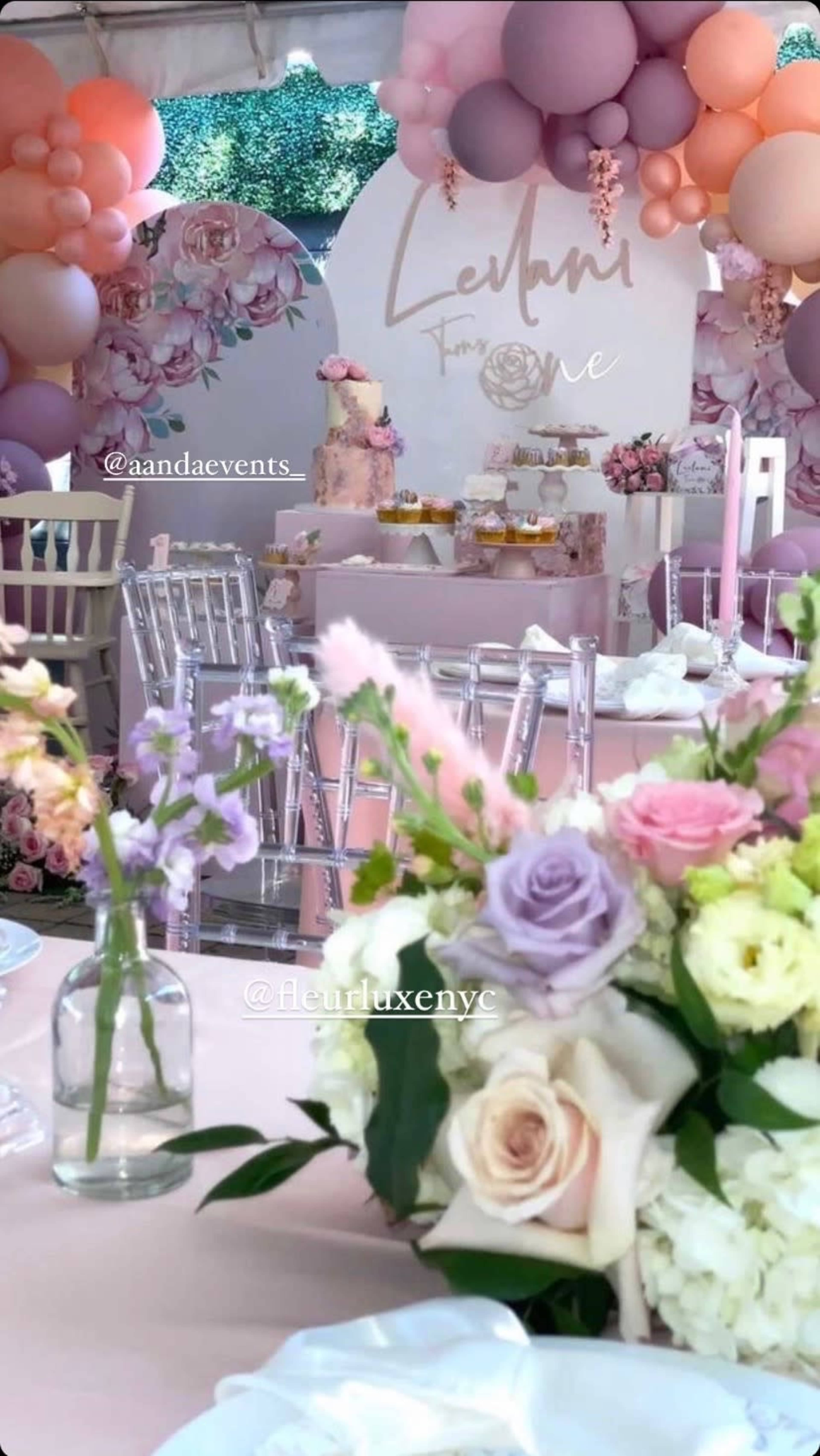 The scene features a decorated event space with pastel-colored balloons, floral arrangements, and a dessert table in the background.