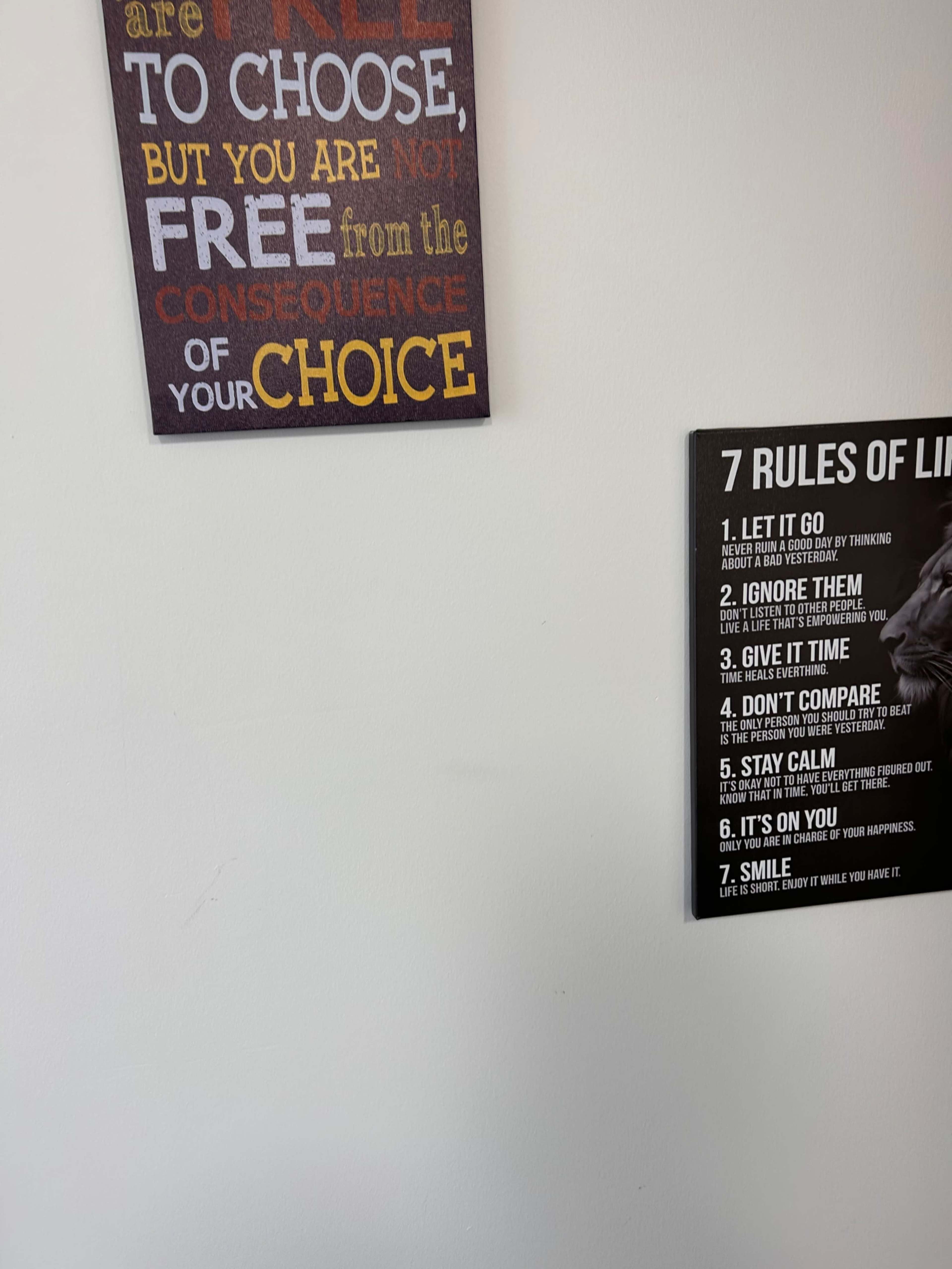 The image shows two framed wall signs: one with a quote about choice and another listing "7 Rules of Life."
