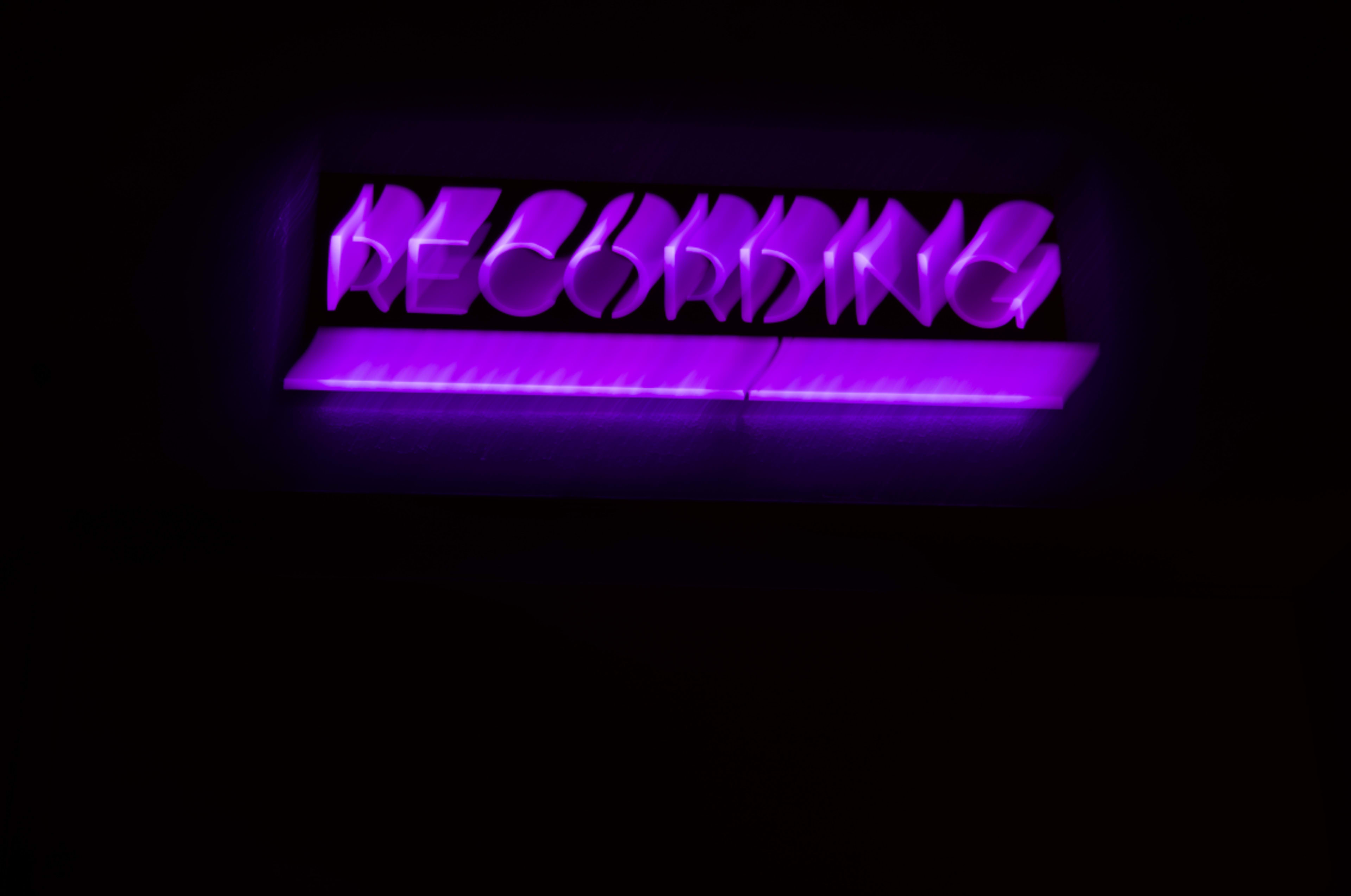 A purple neon sign displays the word "RECORDING."