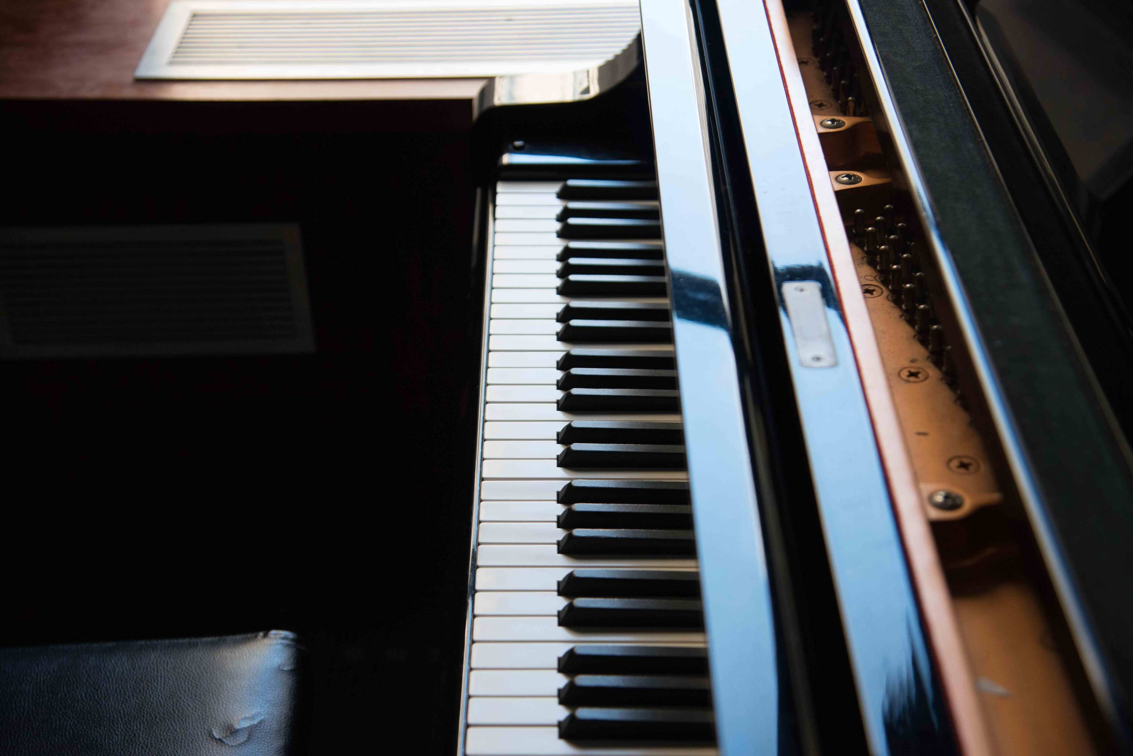 The image shows a close-up view of a piano keyboard with black and white keys.