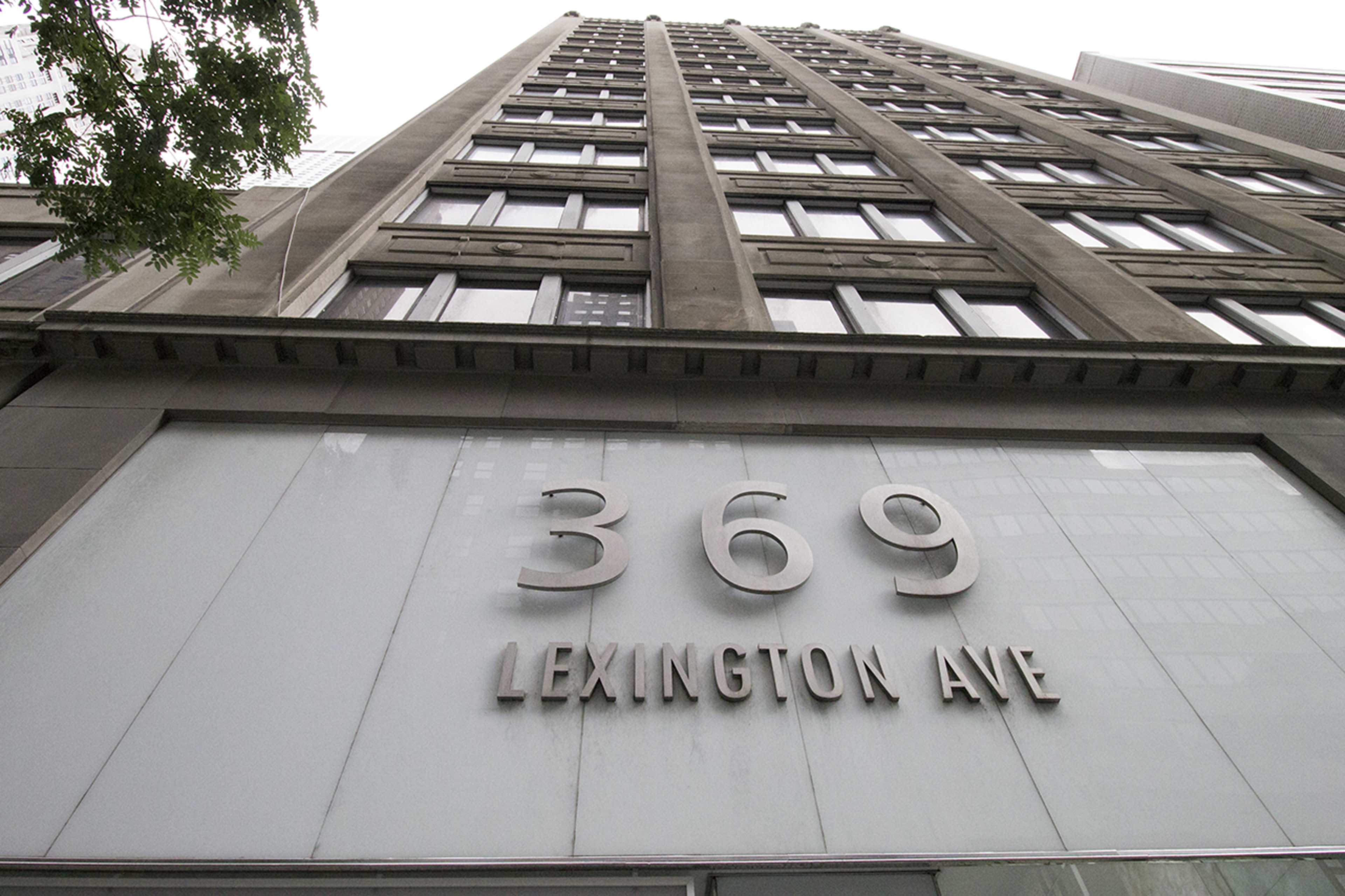 A tall building with a prominent sign displaying "369 LEXINGTON AVE" on its facade.