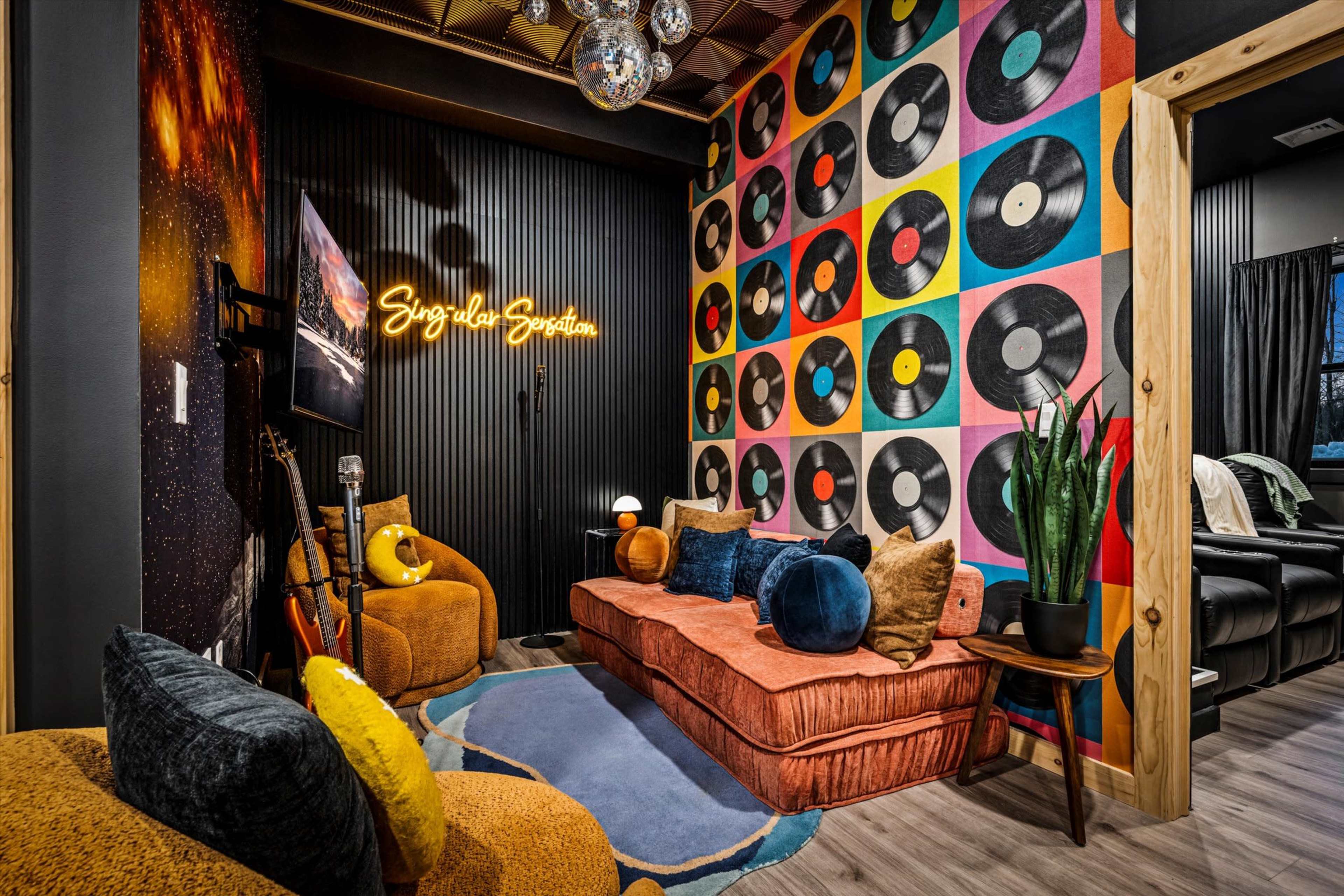 The image depicts a cozy living room featuring a vibrant wall adorned with colorful vinyl record graphics, a plush sofa, and warm lighting.