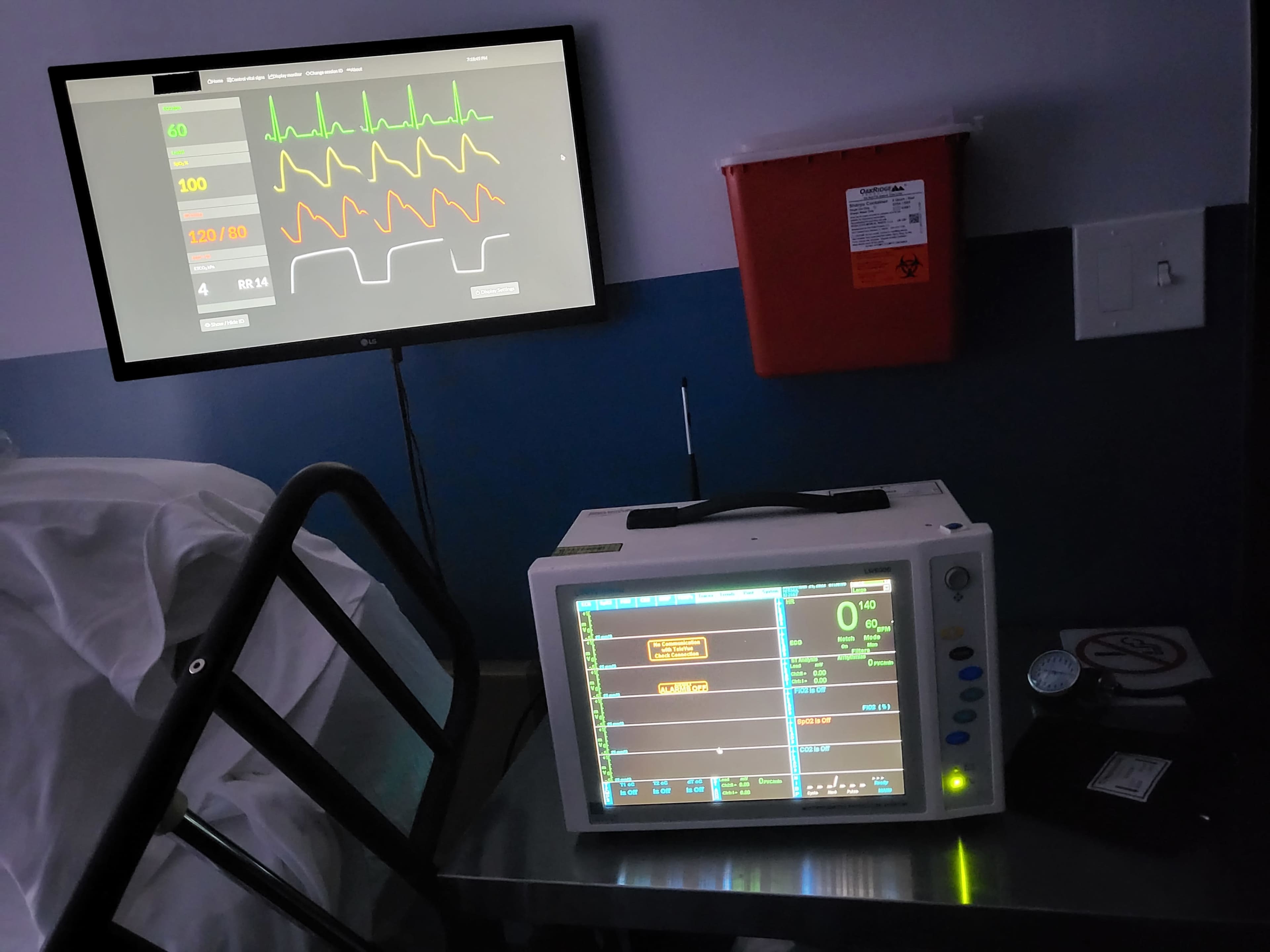 A medical monitoring device displays vital signs on a screen in a hospital room.