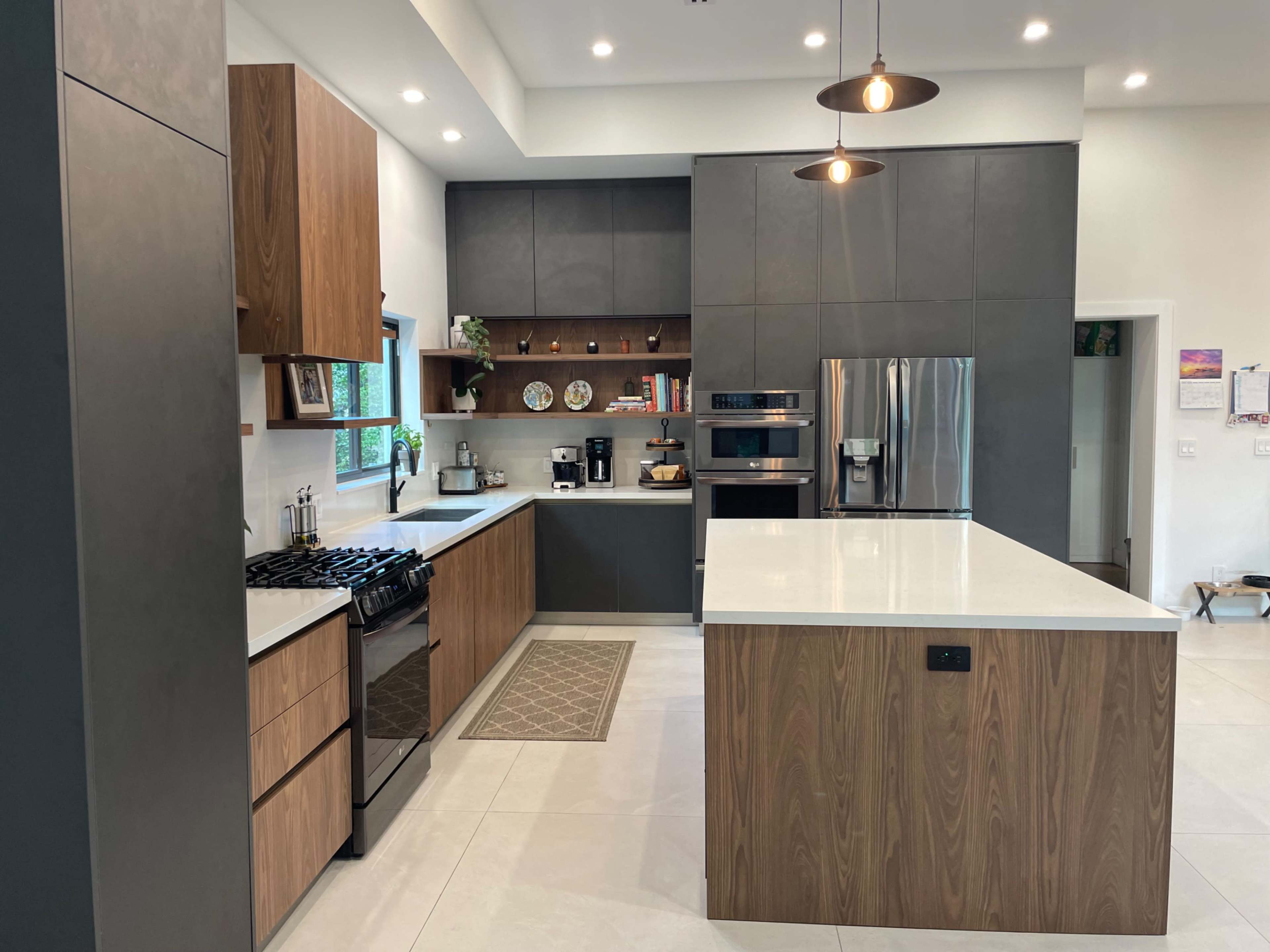 The image showcases a modern kitchen with a large island, sleek cabinetry, and stainless steel appliances.