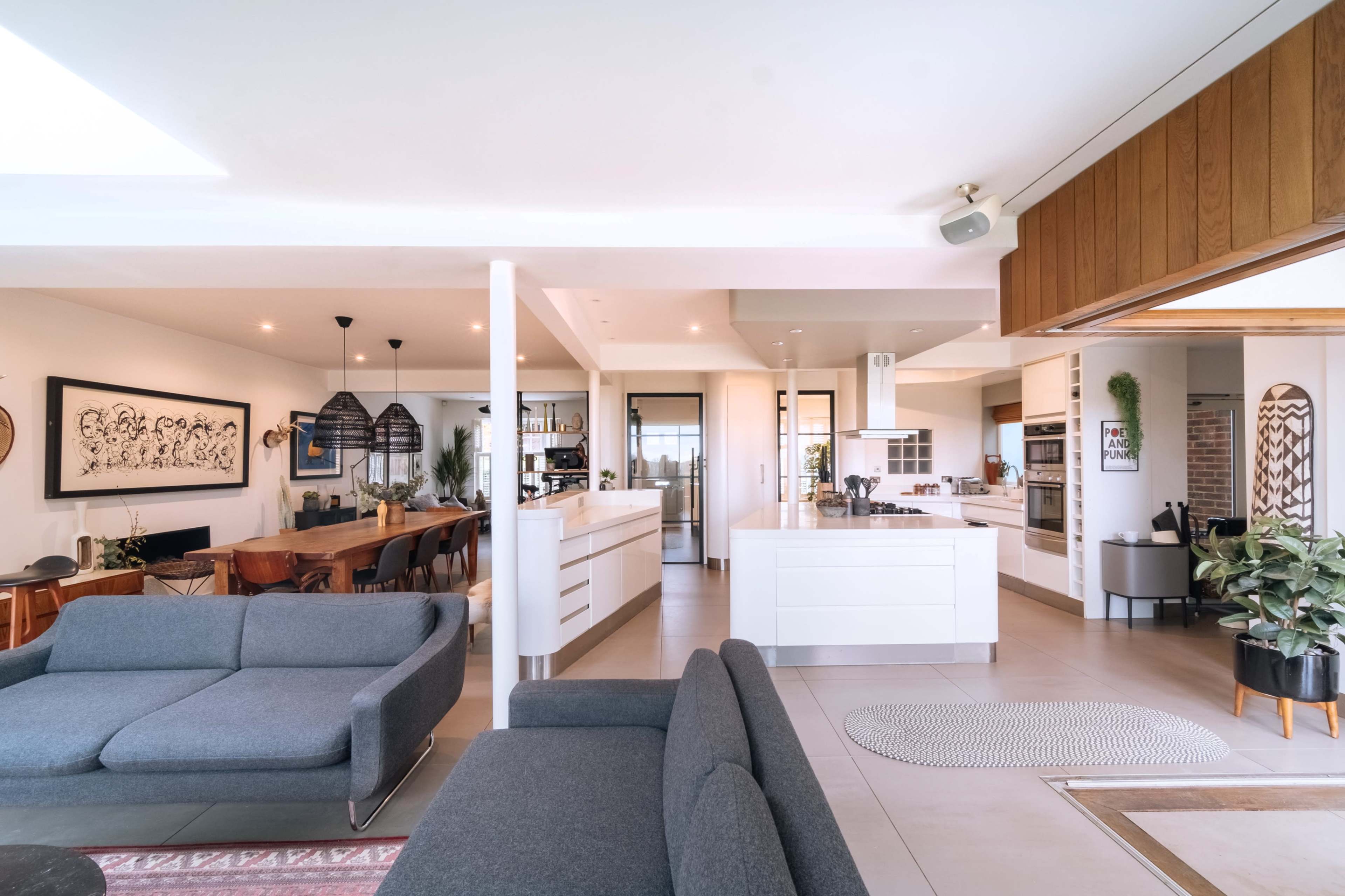 An open-concept living space featuring a modern kitchen, dining area, and comfortable seating arrangement.