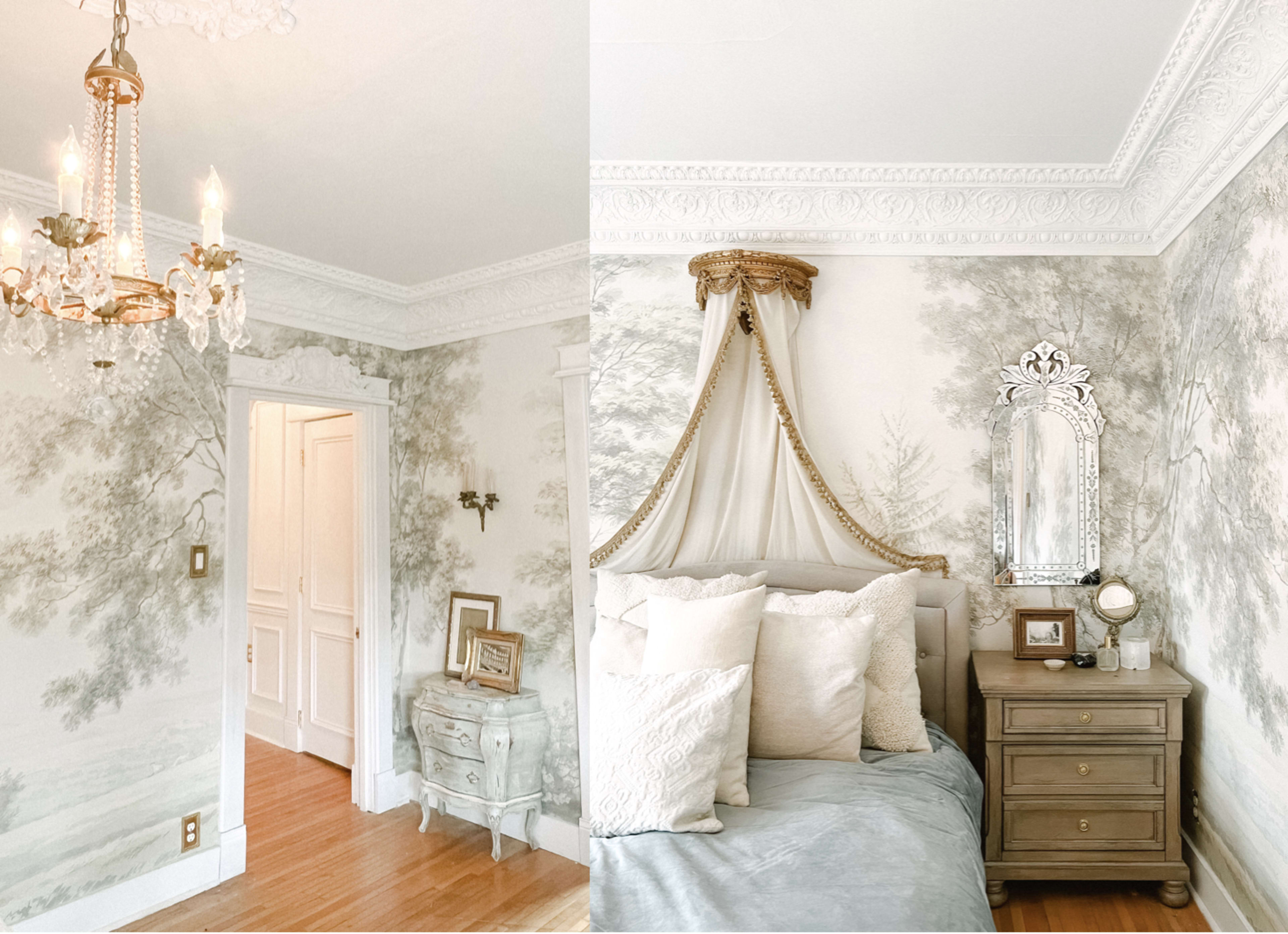 A stylish bedroom featuring intricately patterned wallpaper, a chandelier, and elegant furnishings, including a bedside table with a mirror and decorative pillows on the bed.