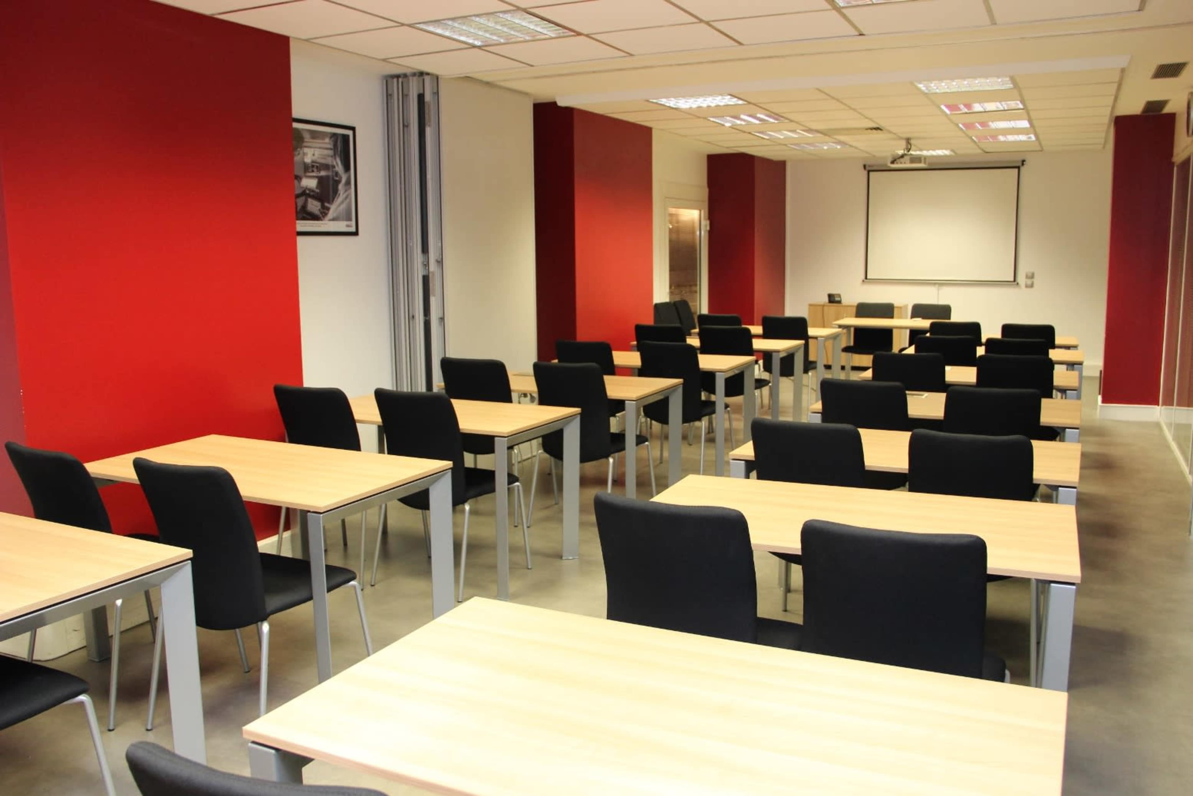 A seminar room with several rows of tables and chairs, arranged for an organized setting.
