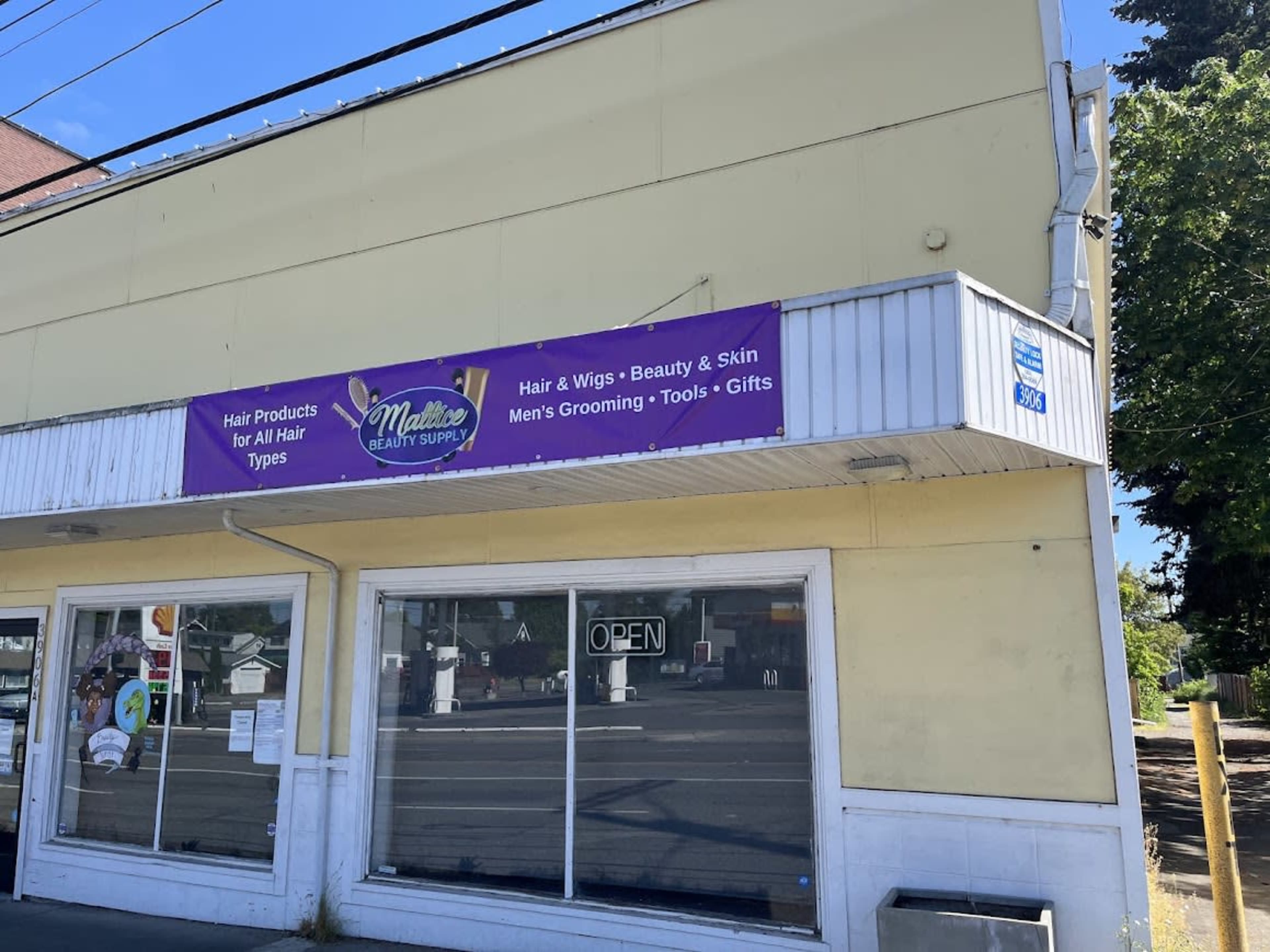 The image shows a storefront with a sign that reads "Maddie's Beauty Supply," advertising hair products, wigs, grooming tools, and gifts.