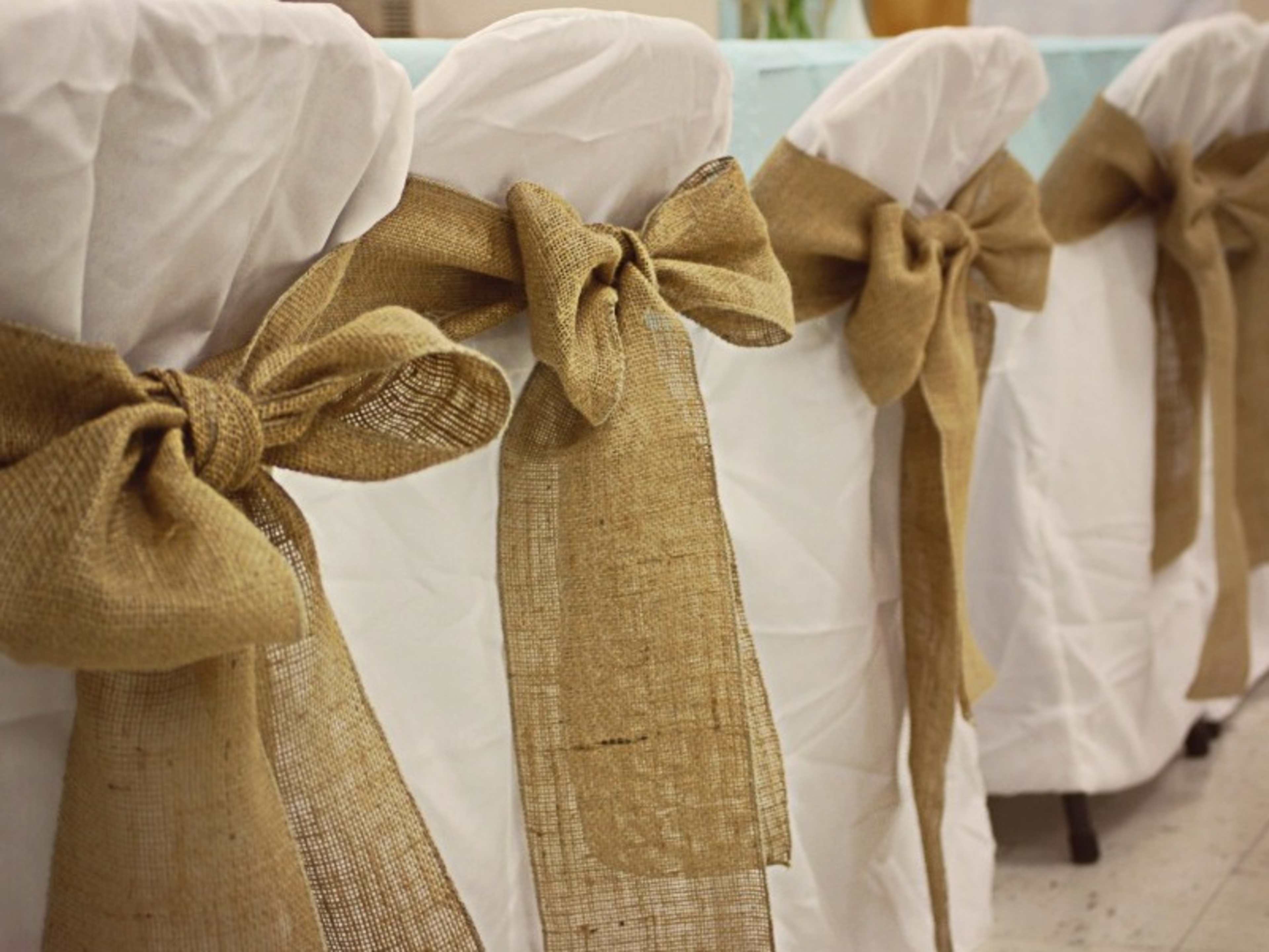 White chair covers with rustic sashes