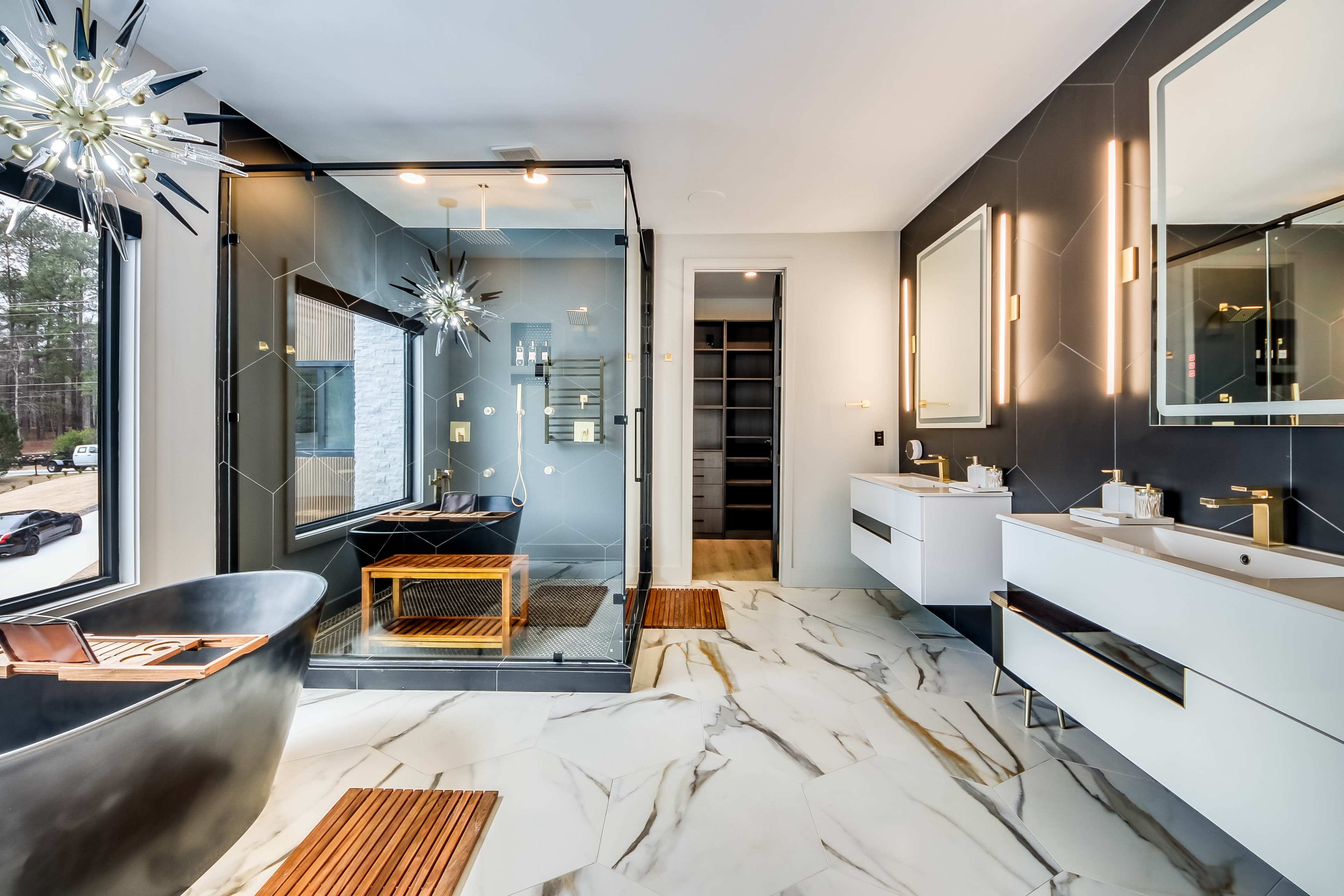 The image shows a modern bathroom featuring a freestanding bathtub, a glass shower enclosure, dual sinks with mirrors, and a marble floor.