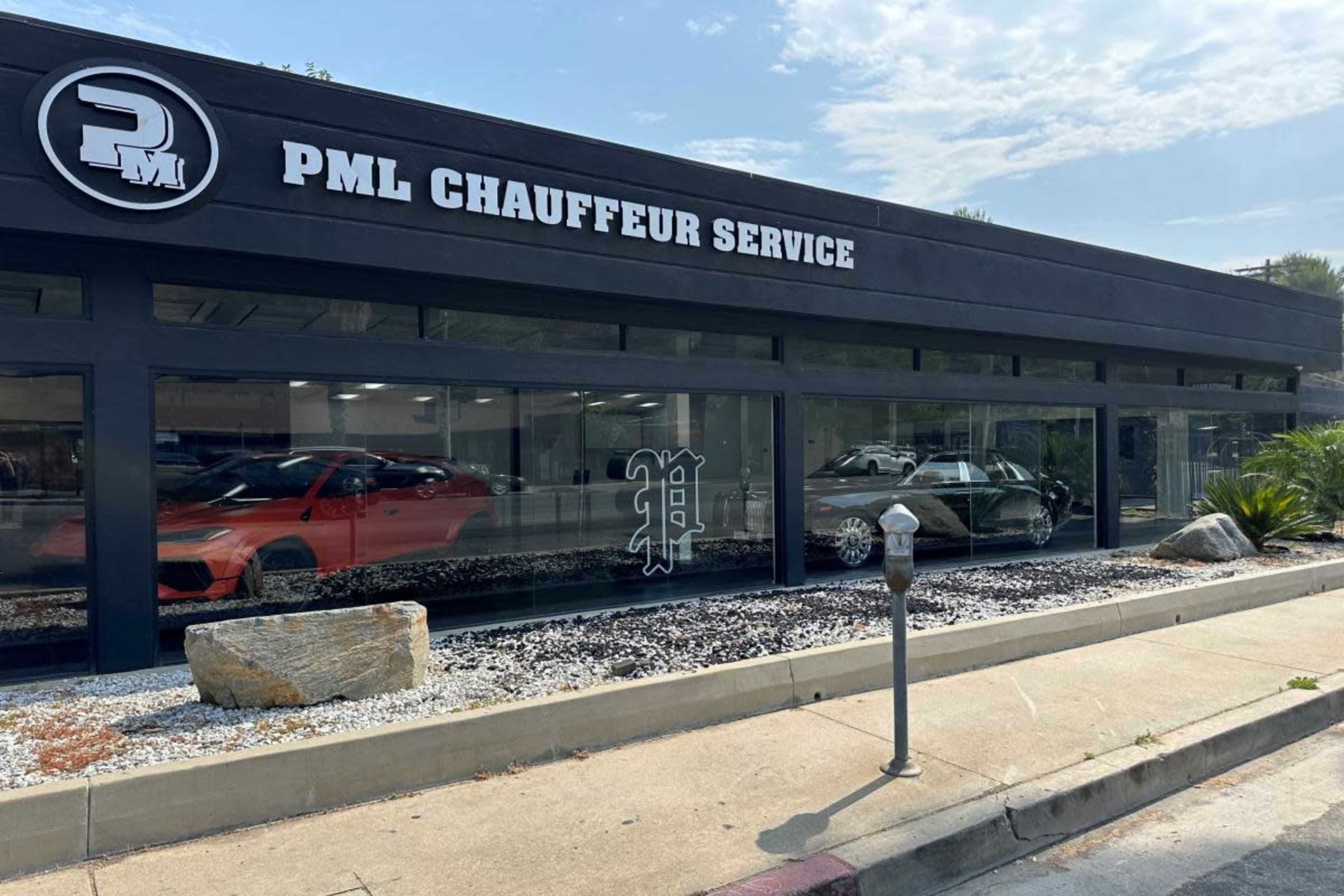 The image shows a modern chauffeur service building with a large glass window displaying parked luxury cars and a sign that reads "PML CHAUFFEUR SERVICE."