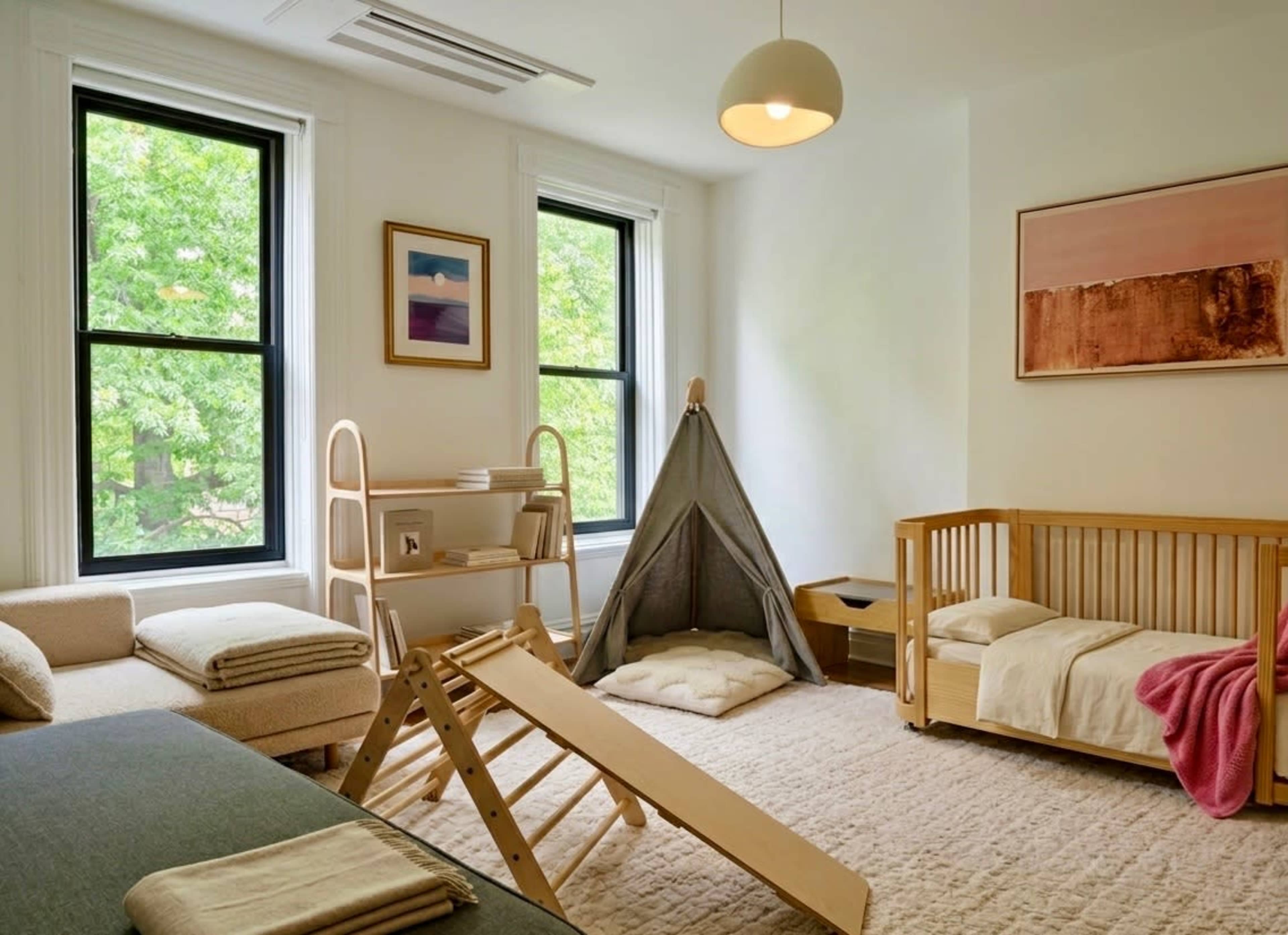 The image depicts a well-lit children’s playroom featuring a low wooden bed, a toddler tent, a climbing structure, and a cozy seating area with throw blankets.