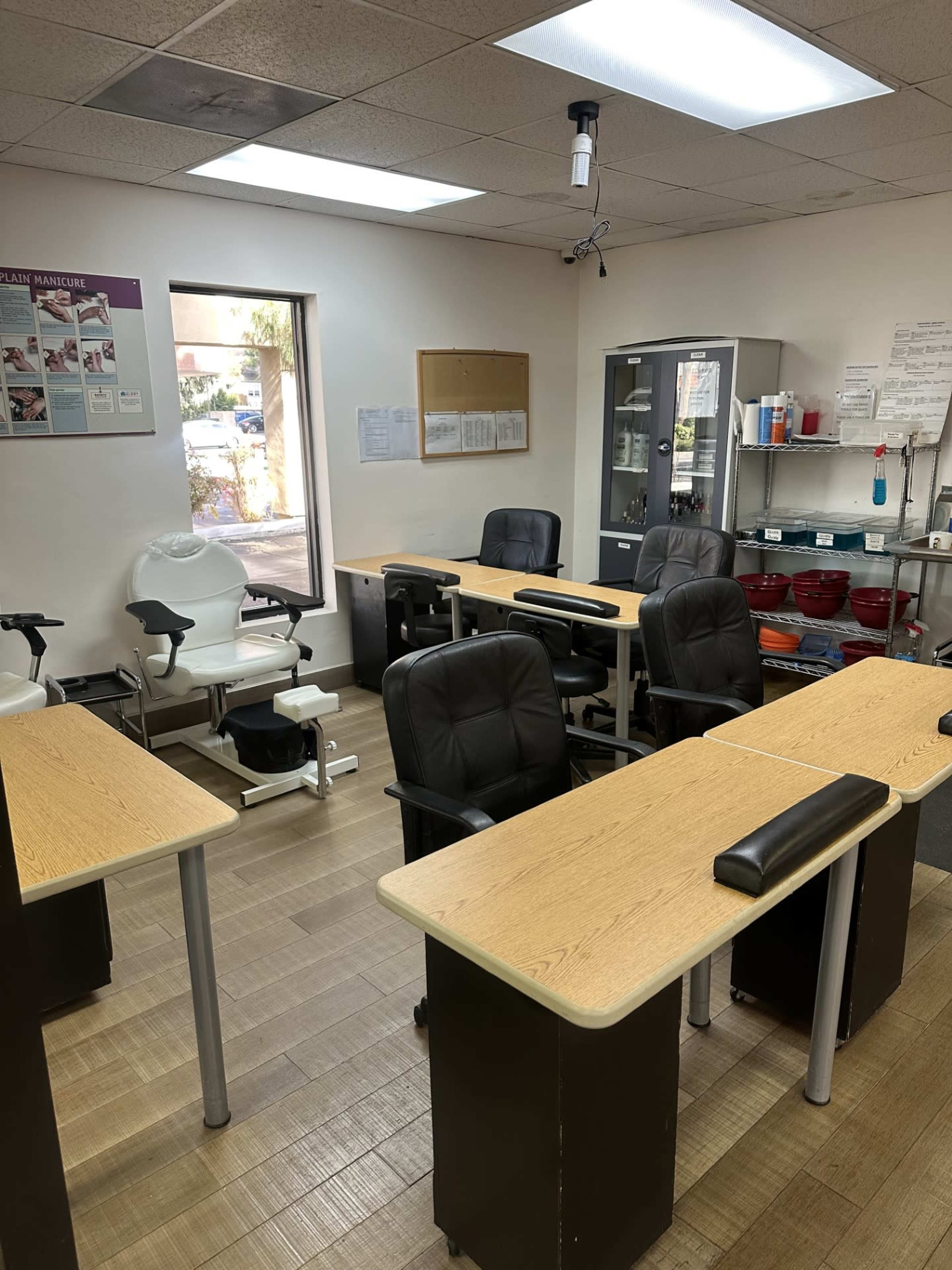 A salon or spa room with several workstations, each equipped with a chair and a table.