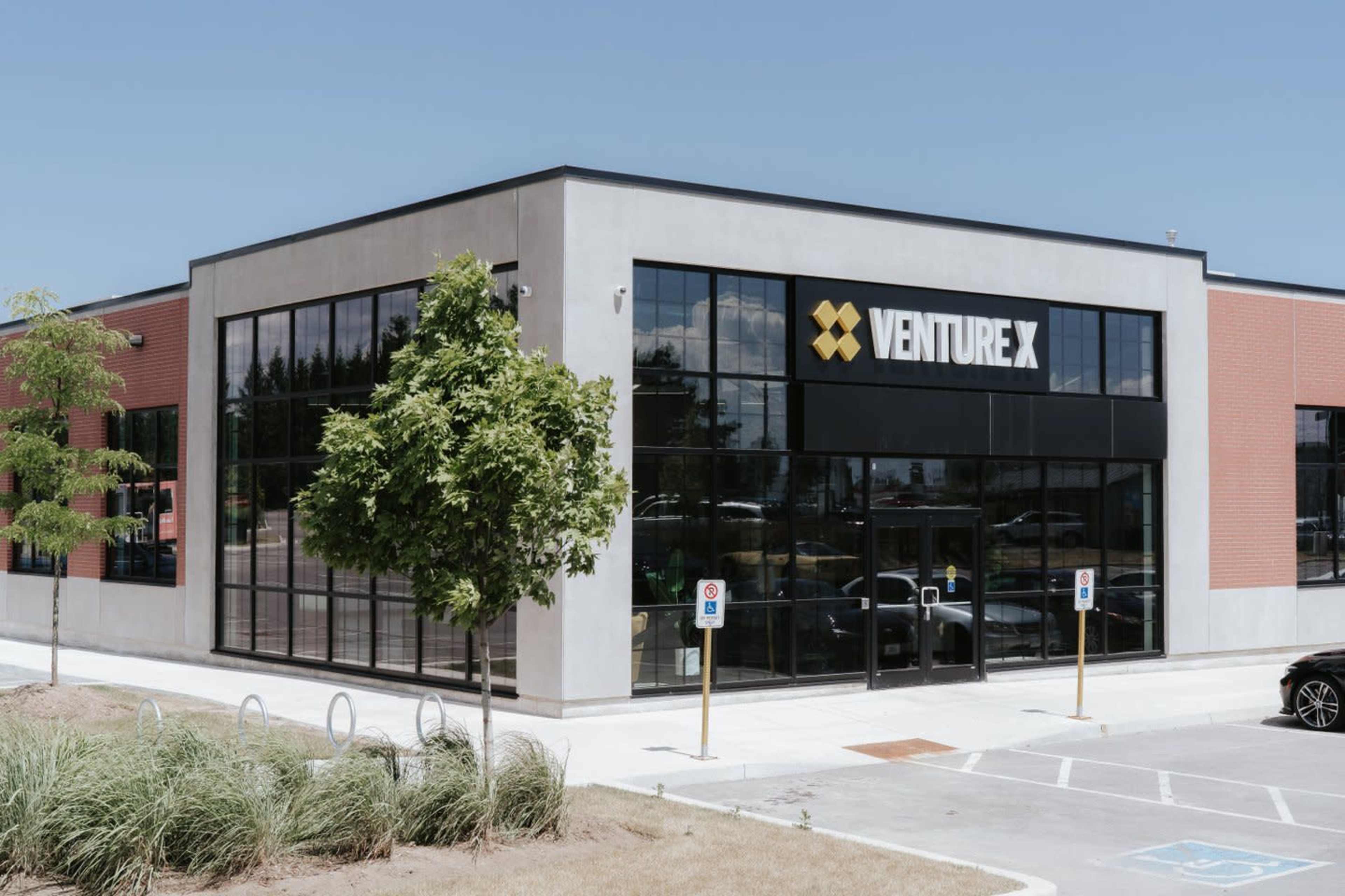 A modern building with large glass windows features a prominently displayed sign for Venture X.
