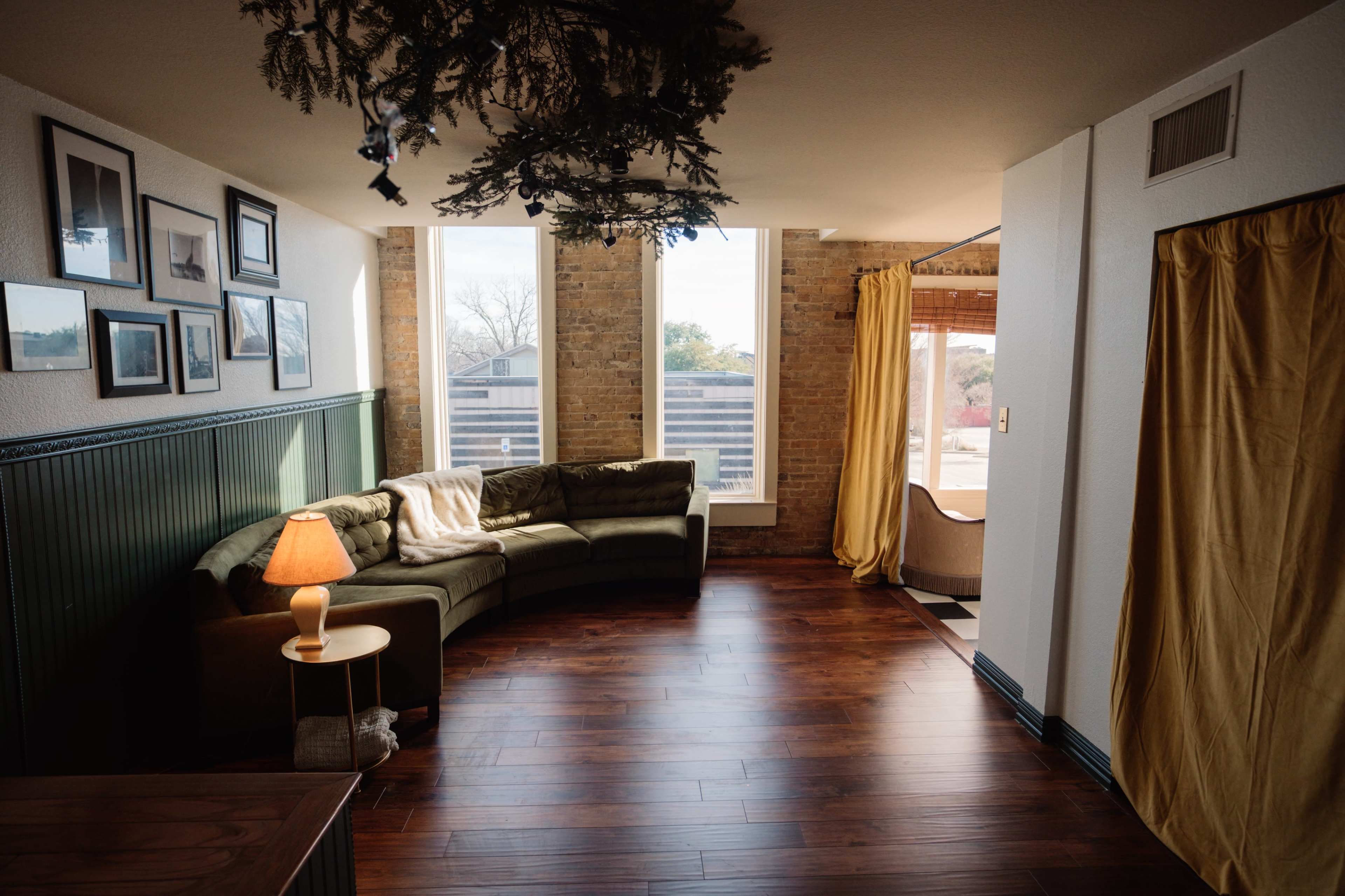 Mid-Century Modern European Inspired Living Room Loft - with exposed brick, large windows for natural light, and access to a full kitchen & bathroom Image in Denton, Denton, TX