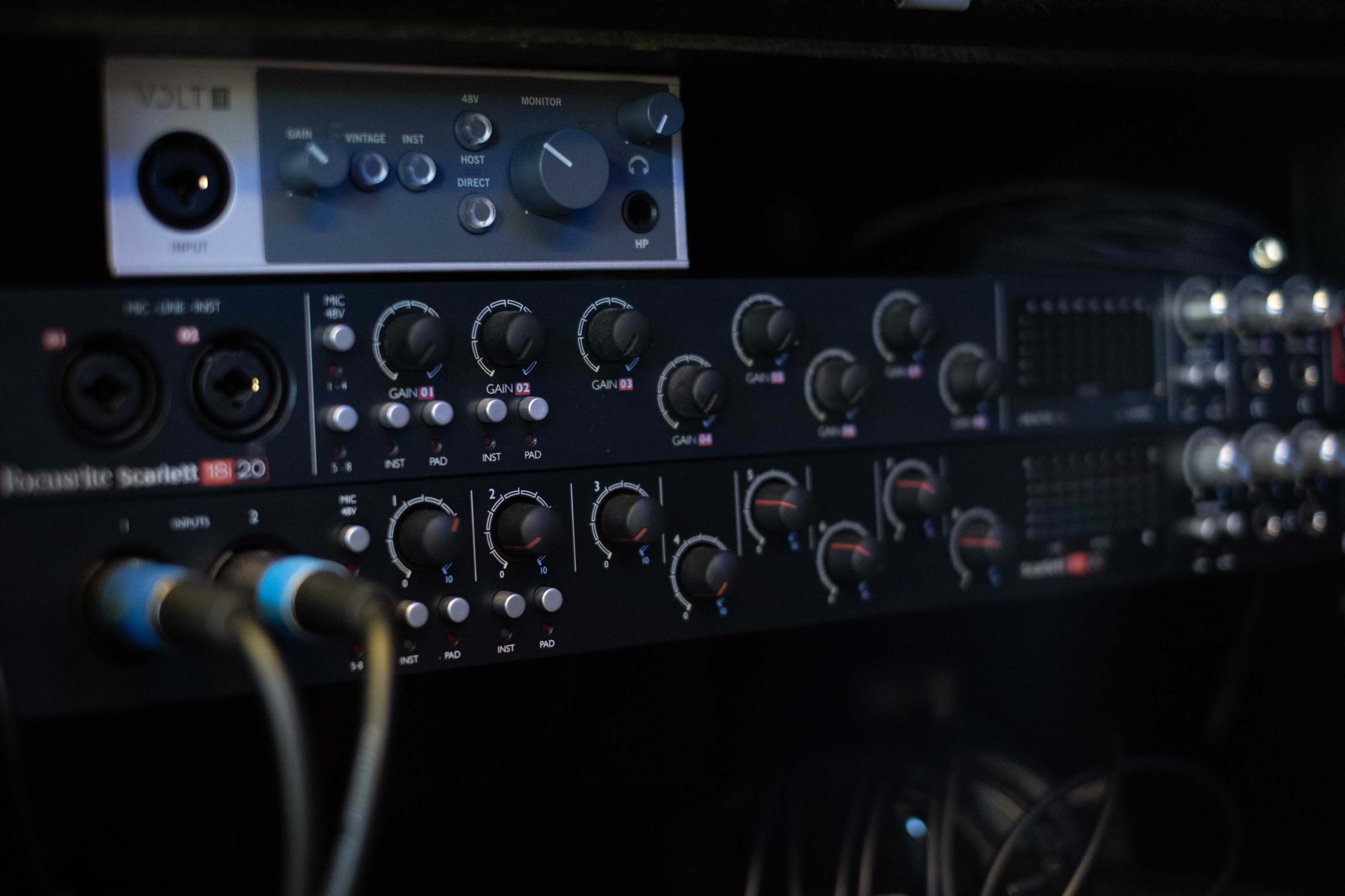 An audio interface with multiple input and output knobs and controls arranged in a black rack unit.