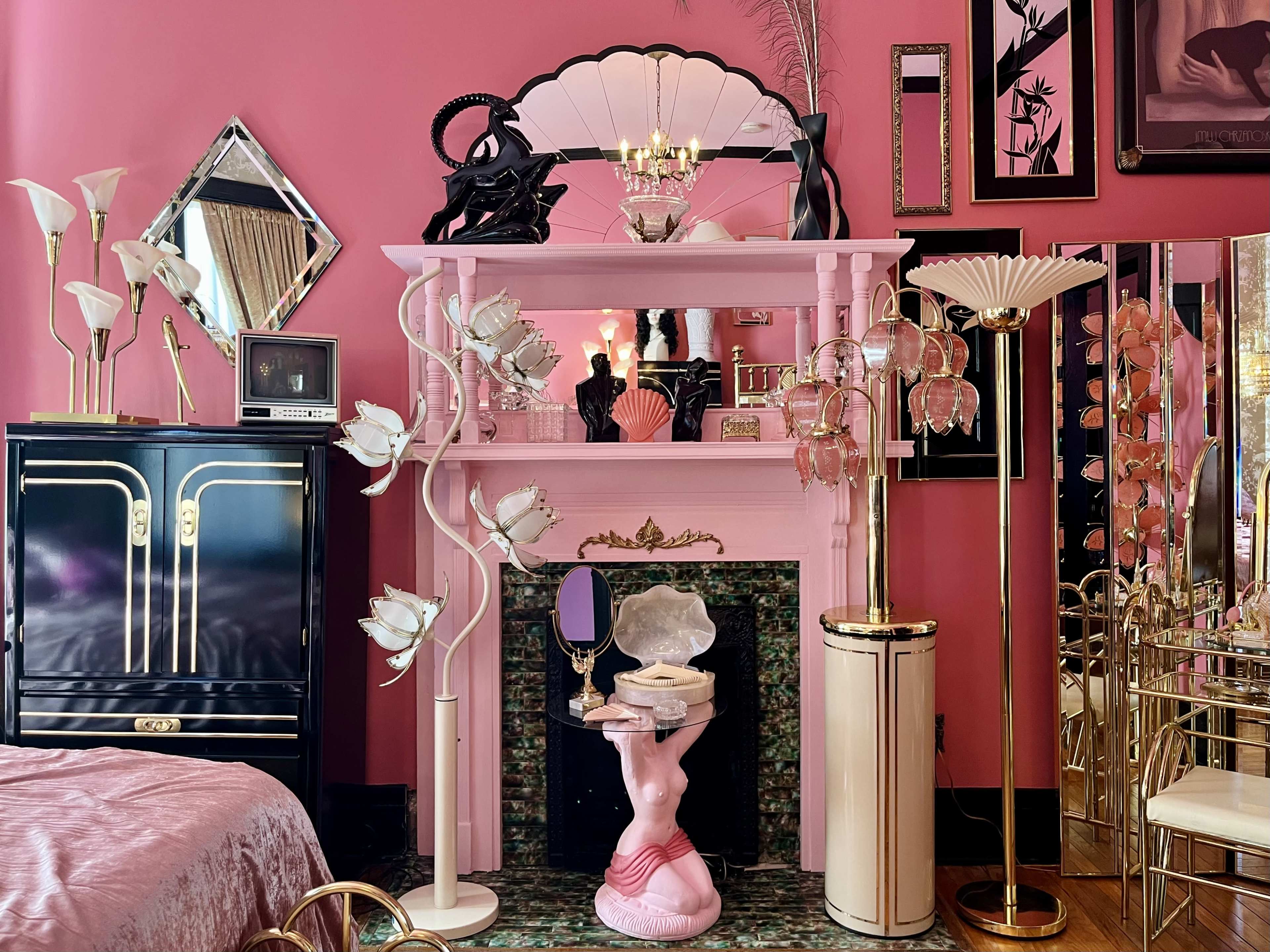 The room features a pink-walled setting with a decorative mantelpiece, a vintage television, and various decorative lamps, including a unique floor lamp shaped like flowers.