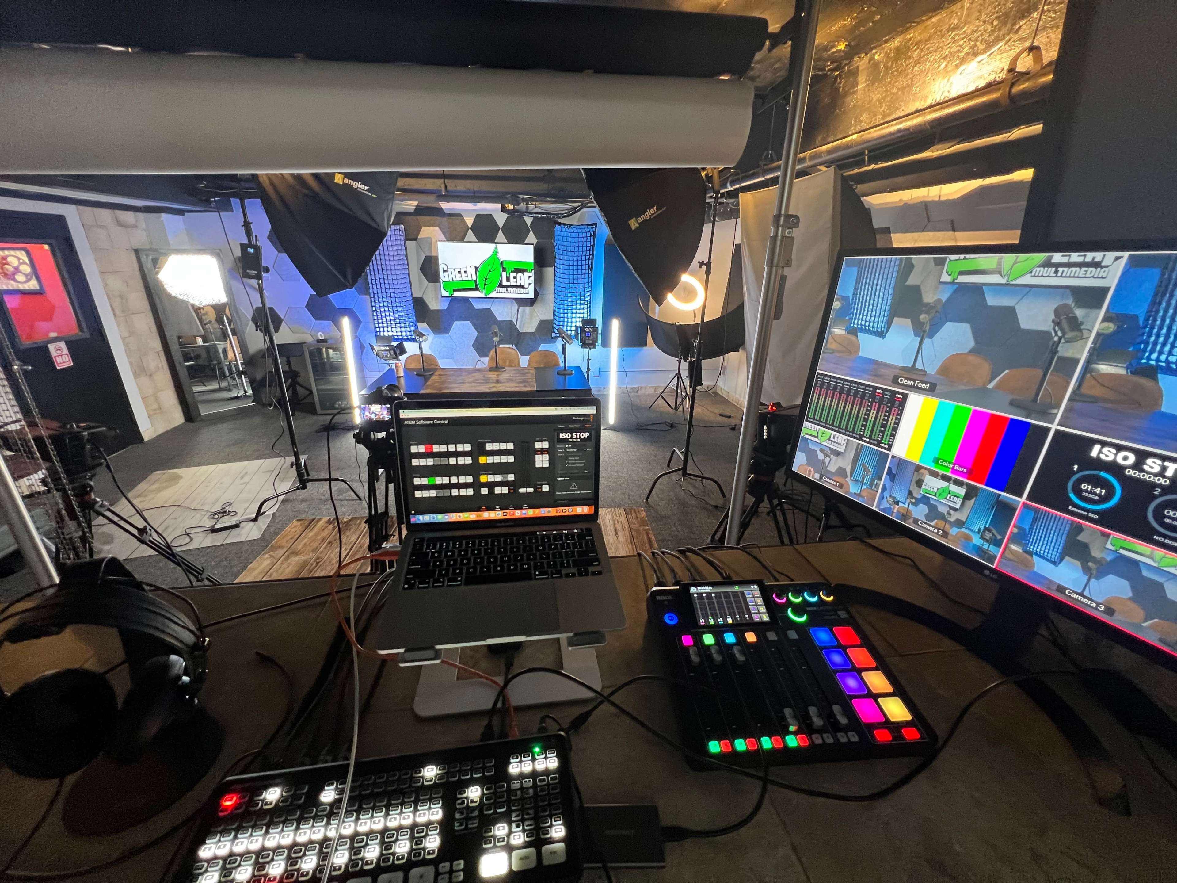 A production studio equipped with cameras, lighting, a mixing console, and multiple screens displaying live video feeds.