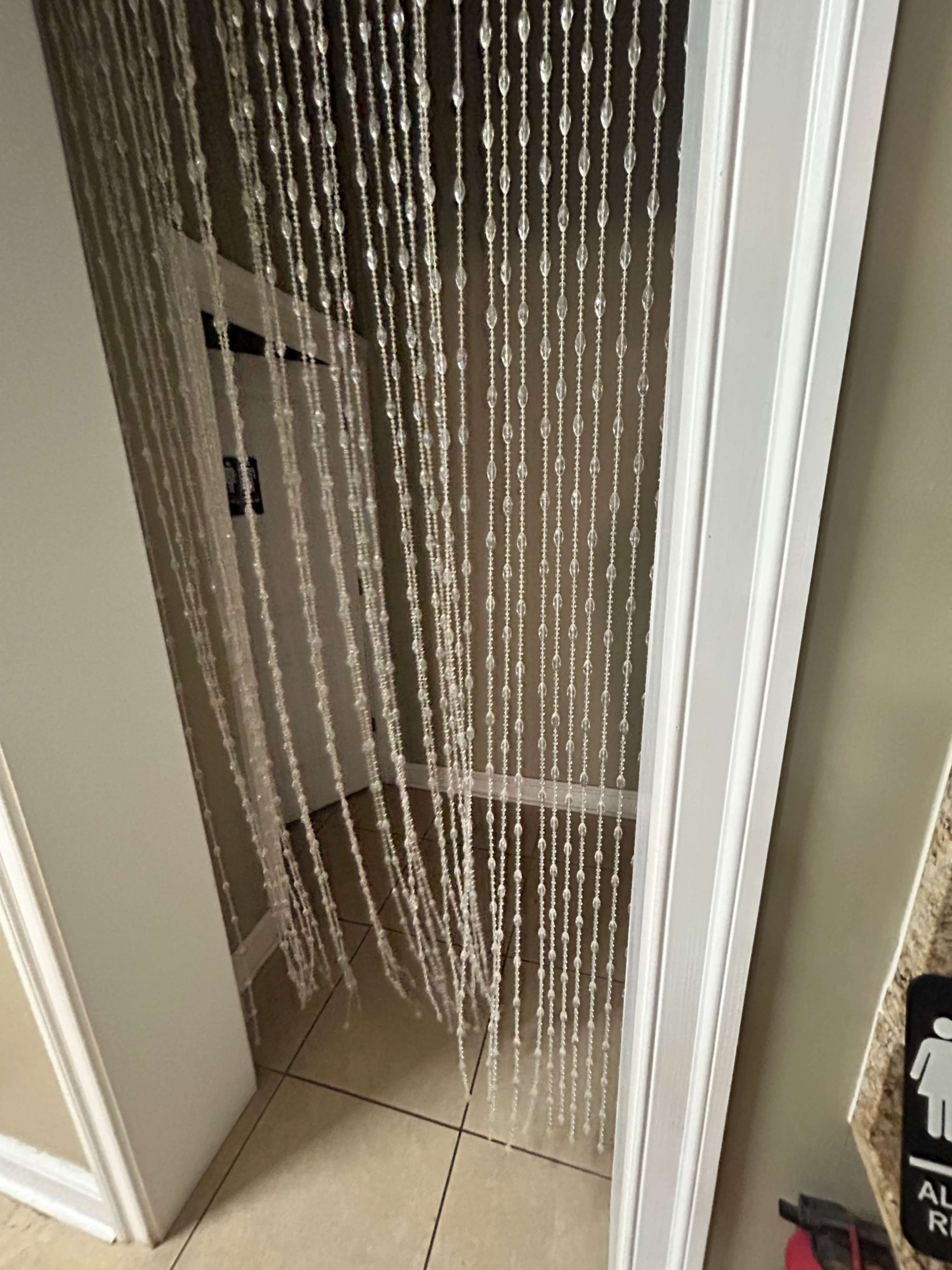 A beaded curtain hangs in a doorway, separating two rooms.