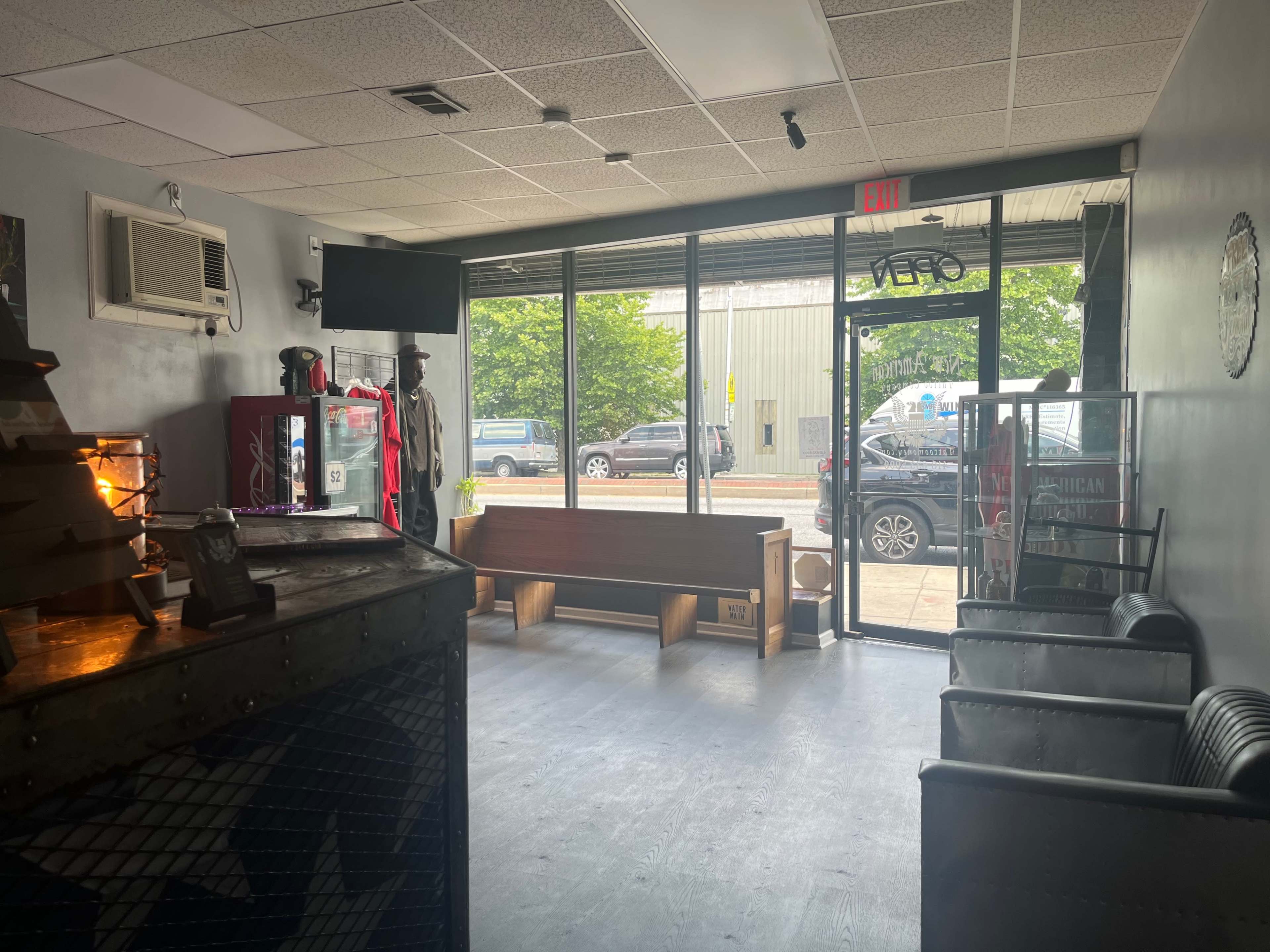 An interior view of a shop with a seating area, television, and large glass doors leading outside.