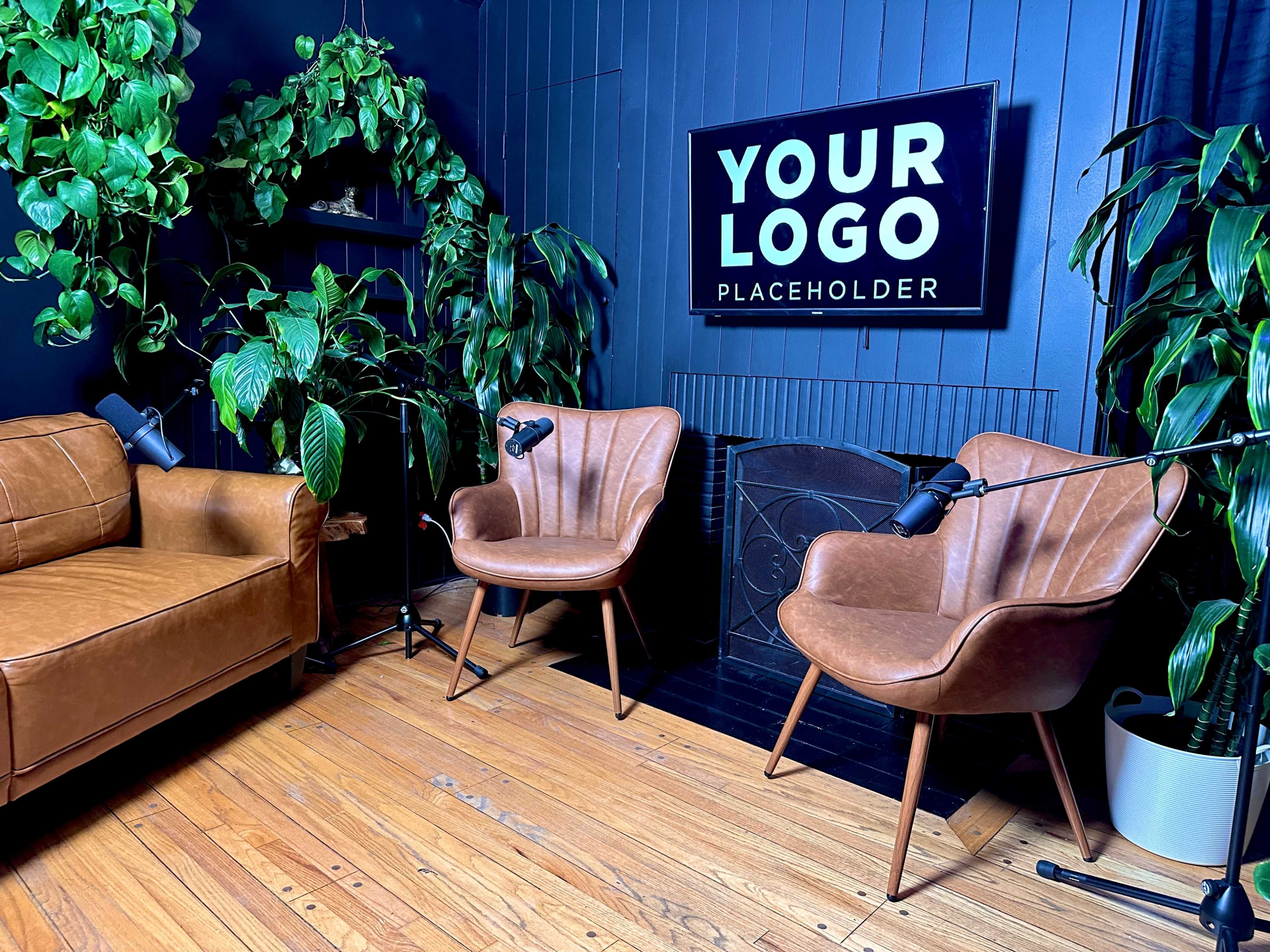 A cozy interior scene features two brown armchairs and a leather sofa surrounded by lush green plants, with a sign that says "YOUR LOGO PLACEHOLDER" on the wall.