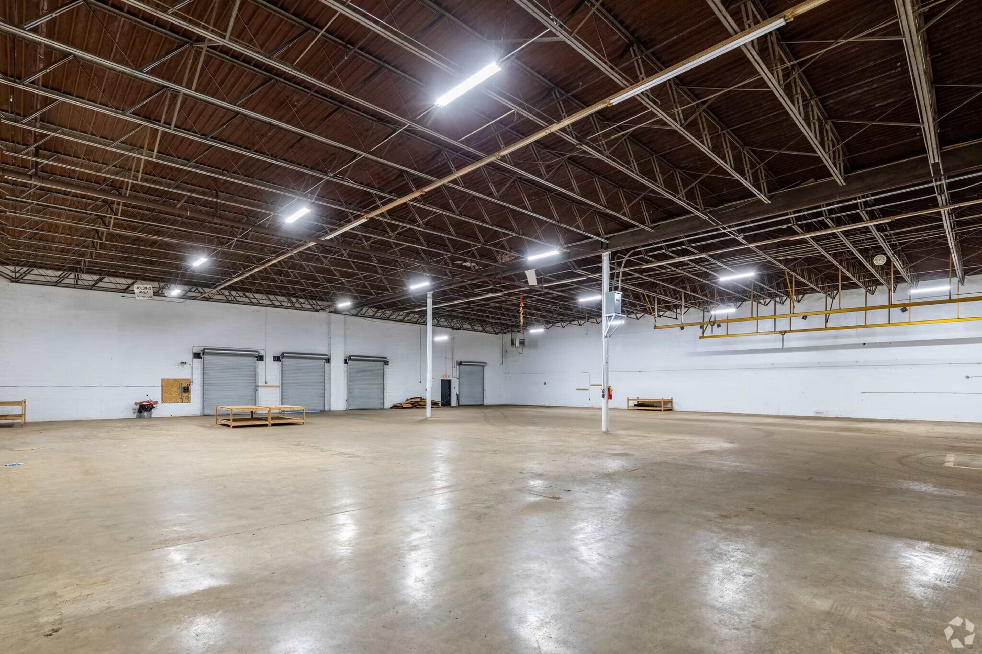 A large, empty warehouse space with high ceilings and minimal interior features.