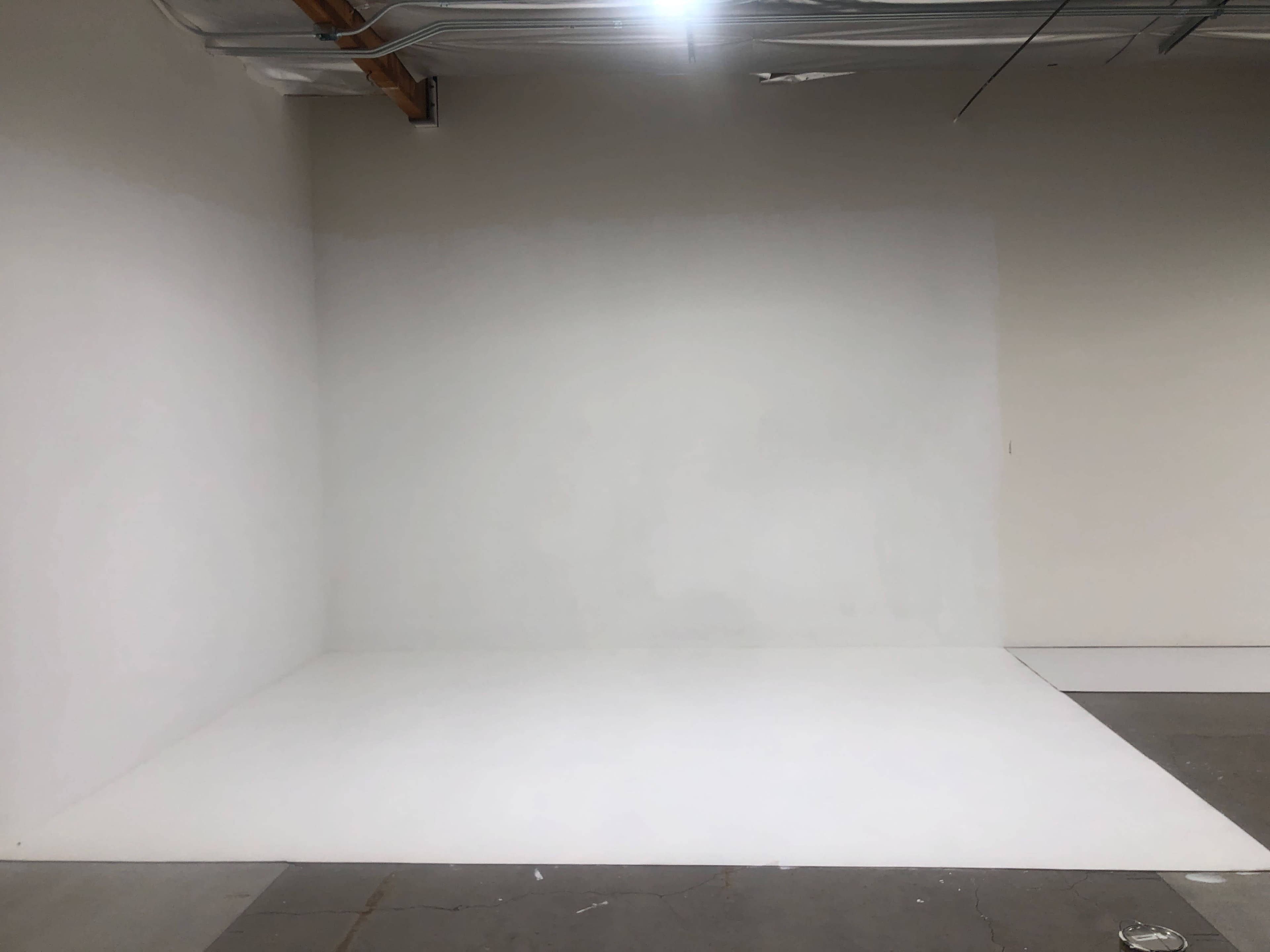 An empty room with white walls and a smooth white floor.