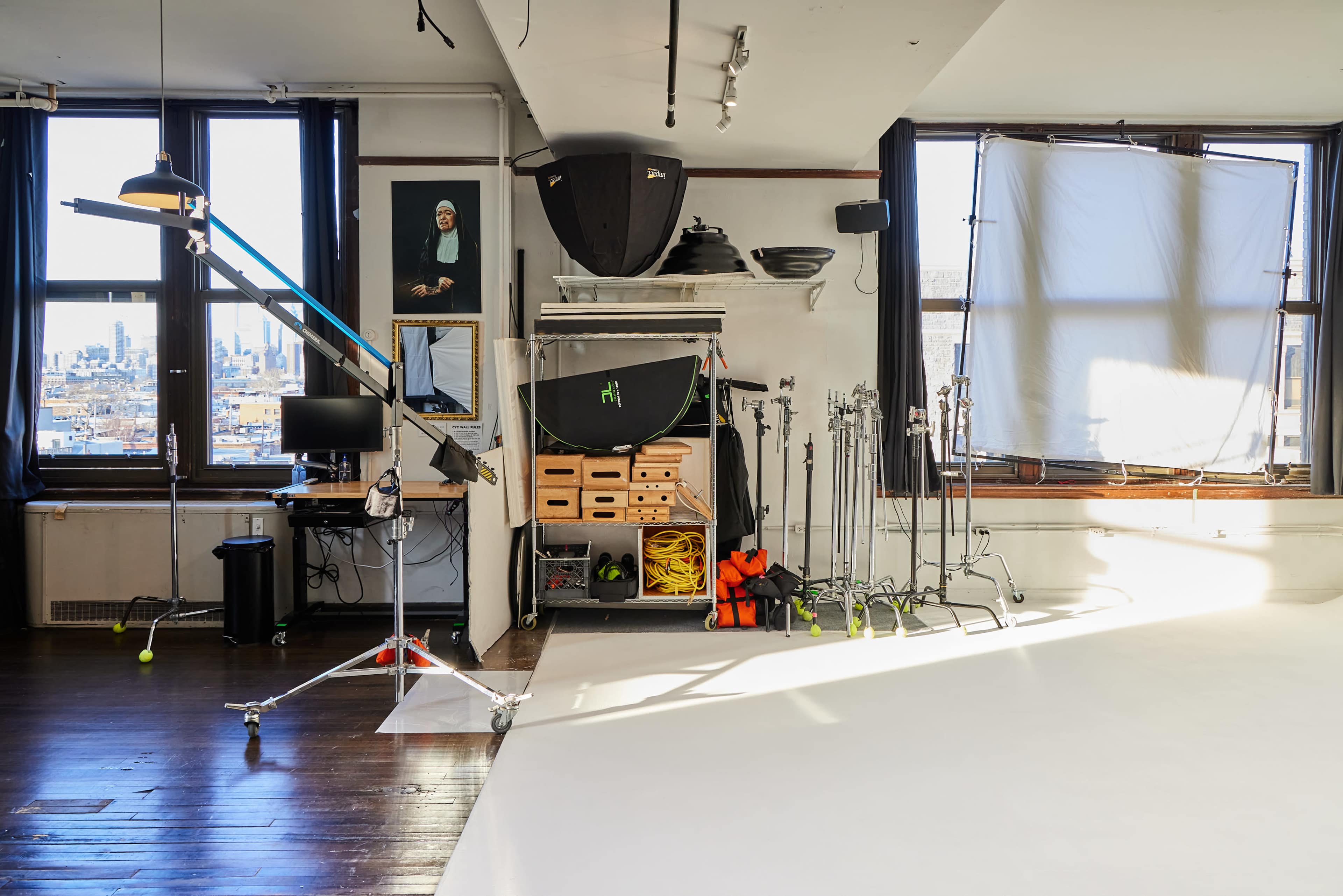 A photography studio with various equipment, including lights, a backdrop, and storage for tools.
