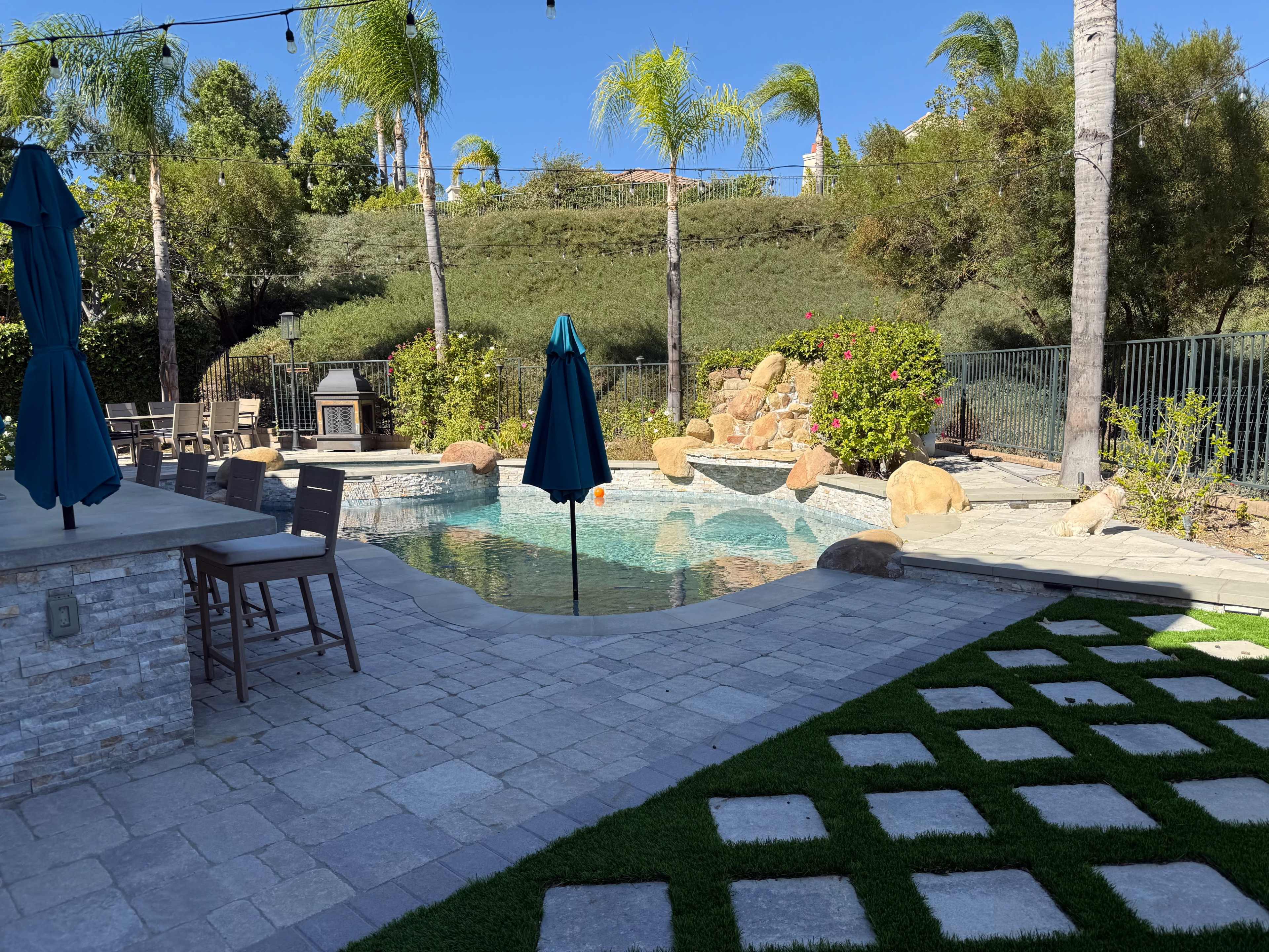 Discover a hidden gem — Surrounded by green hills and palm trees, this tranquil backyard retreat offers a saltwater pool, jacuzzi, and elegant entertaining area. Perfect for celebrations, photoshoots, or relaxing under twinkling string lights. 💦🌴 Image in Stevenson Ranch, Valencia, CA