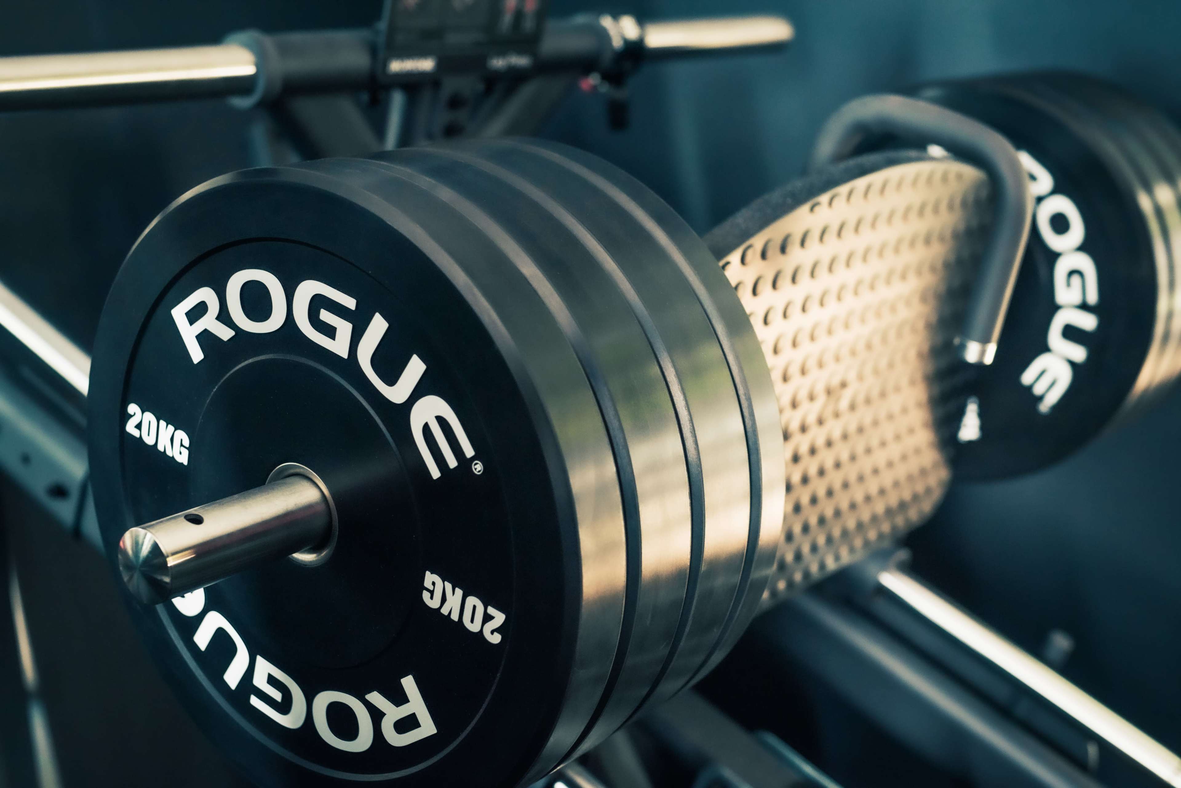 The image shows a barbell loaded with weights on a gym rack.