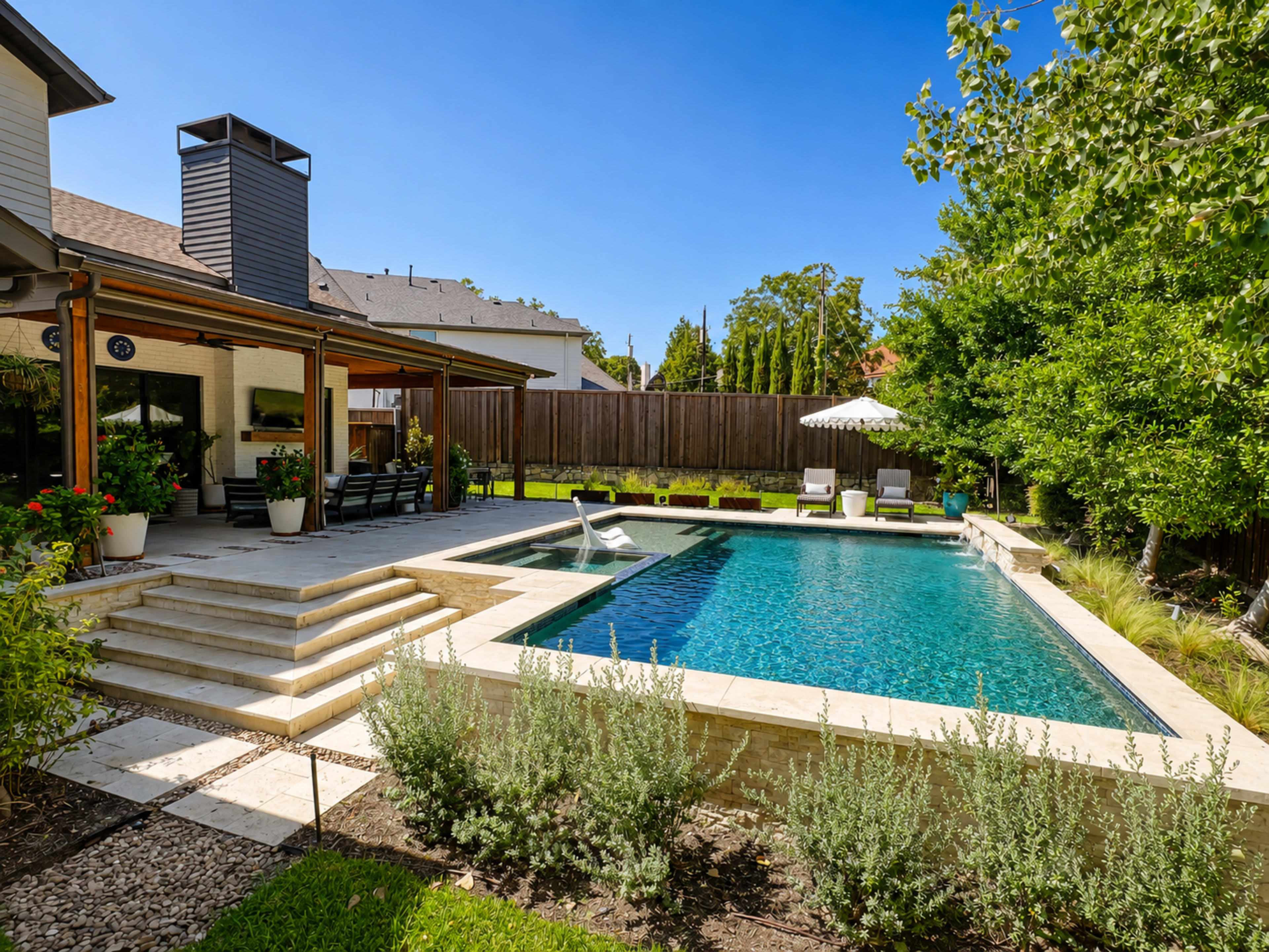 The image shows a spacious backyard featuring a rectangular swimming pool, surrounded by landscaped greenery and a patio with outdoor seating.