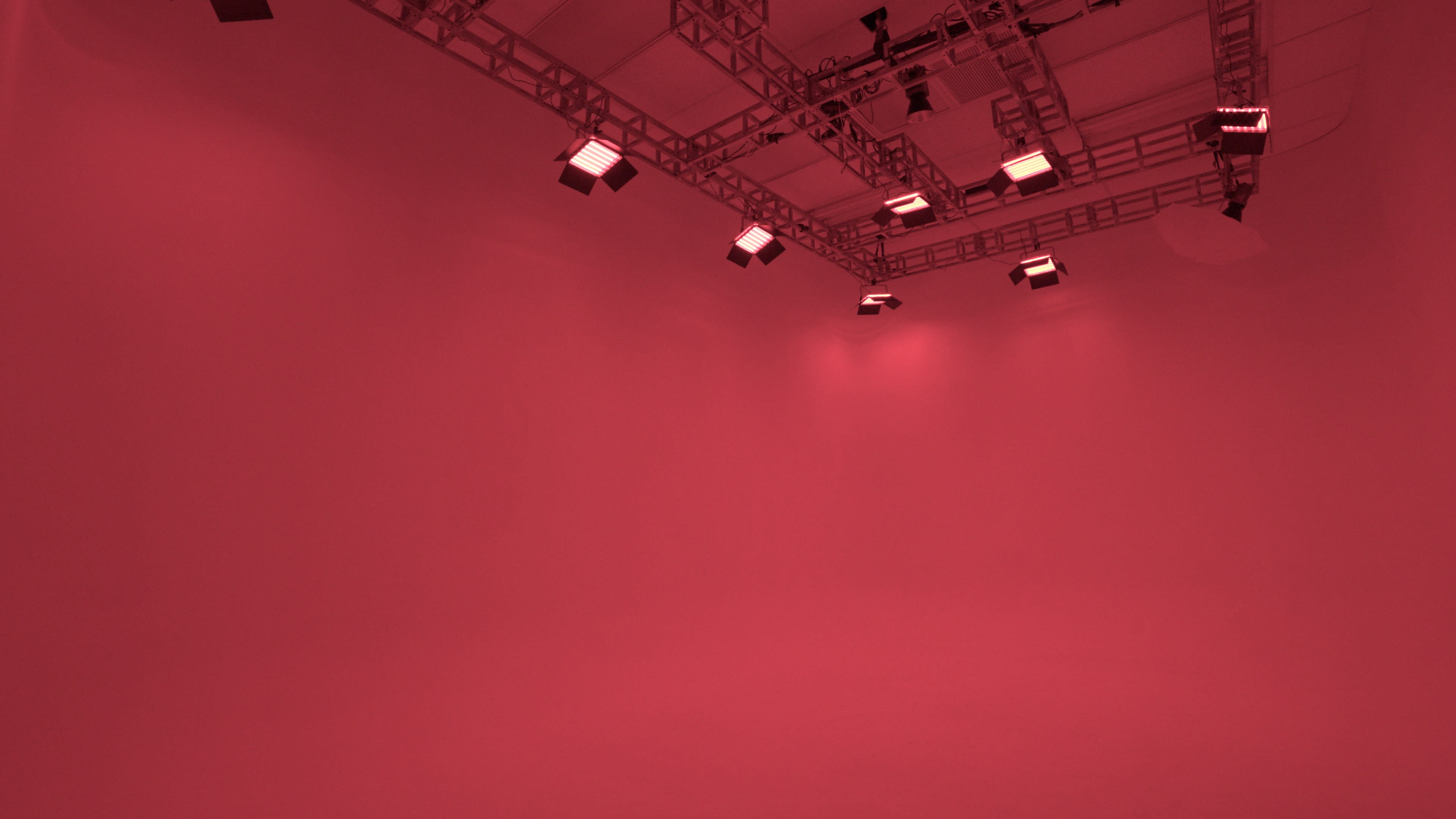 A studio space with red walls and overhead lights.
