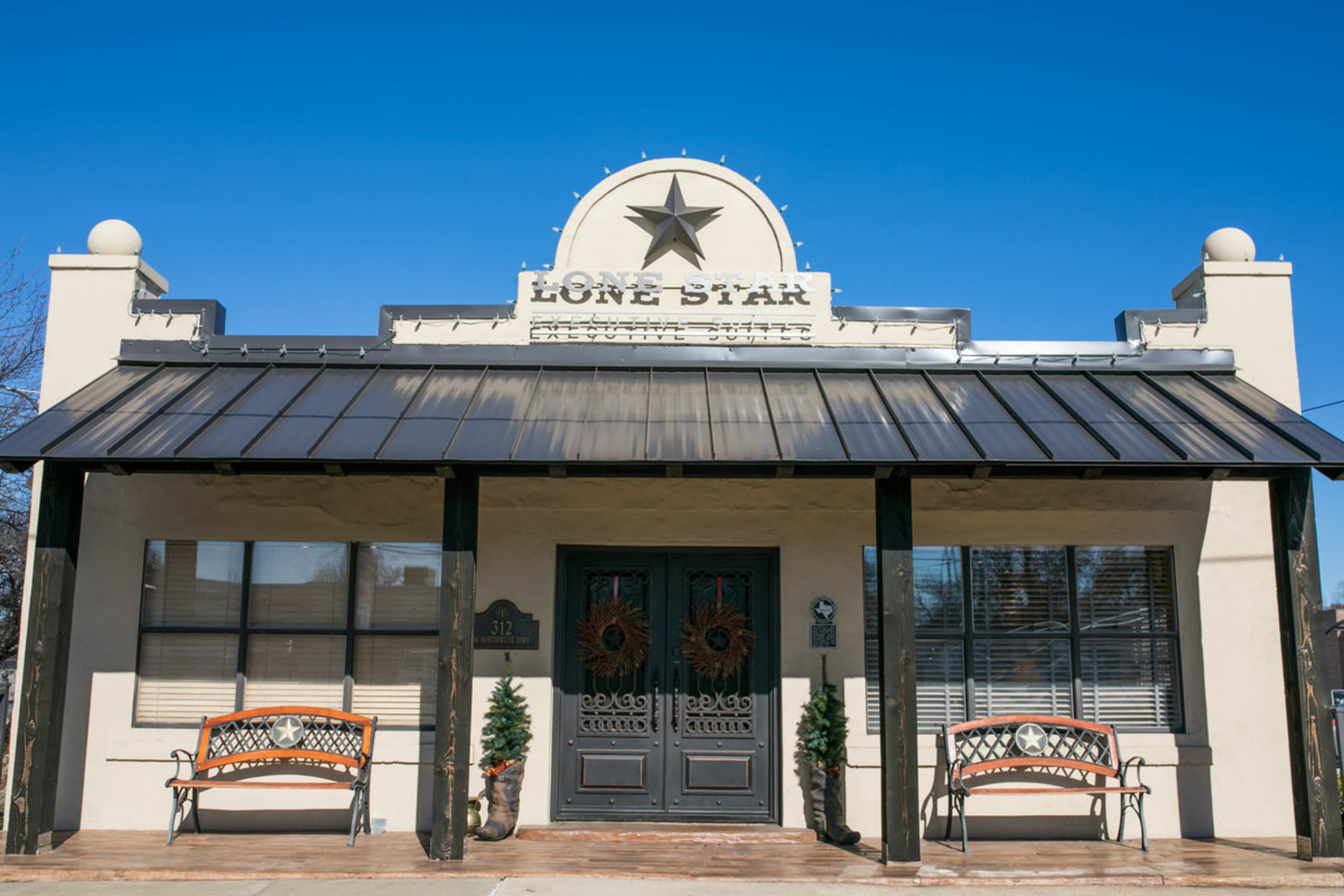 A one-story building with a flat roof, featuring the words "Lone Star" above the front entrance, flanked by two decorative benches.