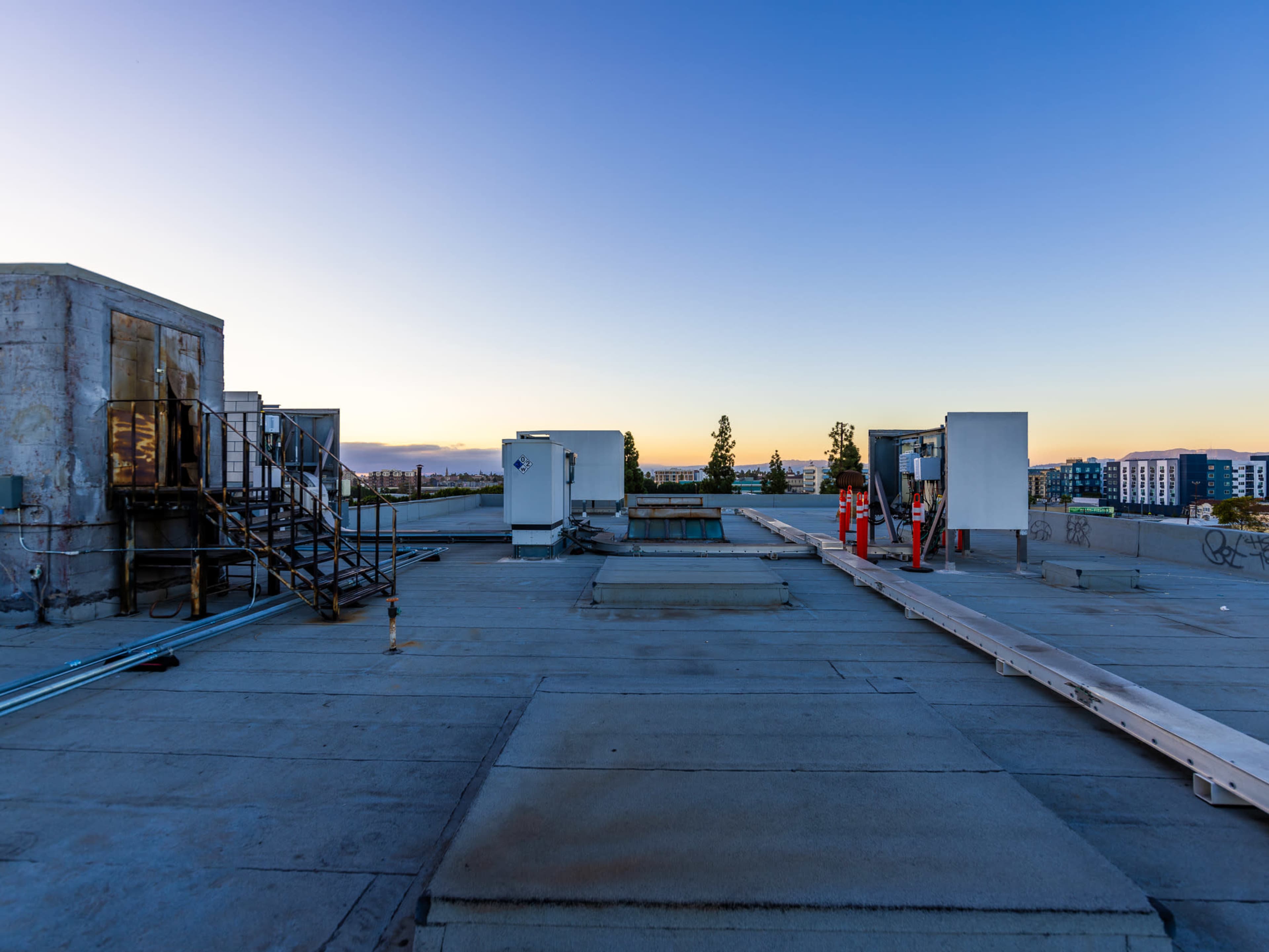 A flat rooftop with industrial equipment and a clear sky at dusk.